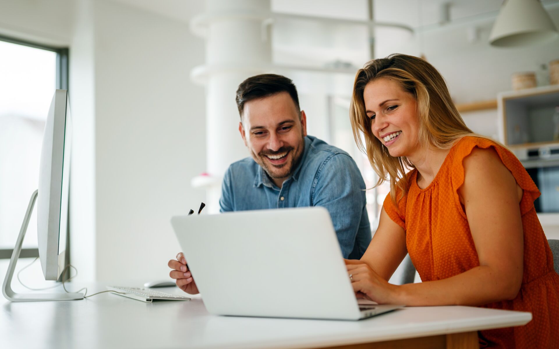 A couple sit at a computer.