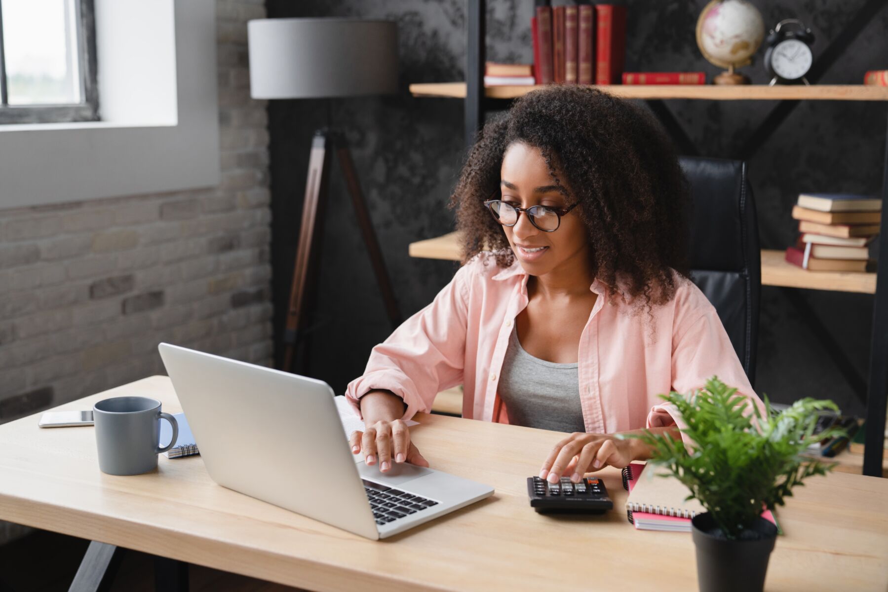 A young woman uses a computer at a desk.