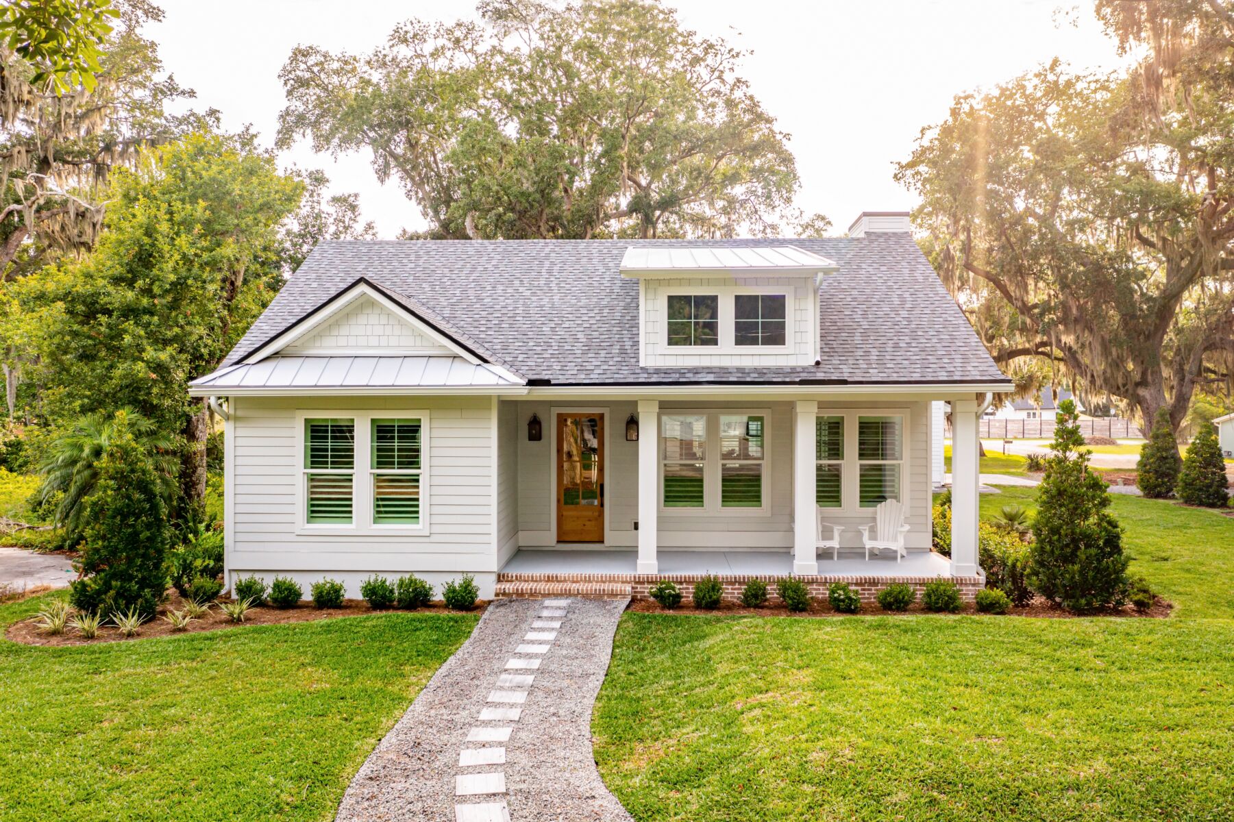 A classic white house surrounded by trees.