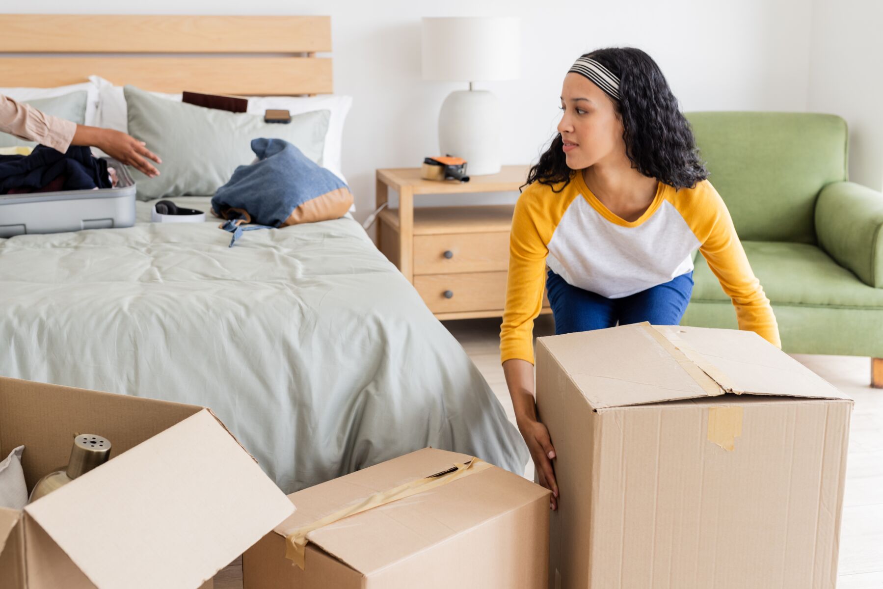 A woman unpacking boxes in a PadSplit living room.