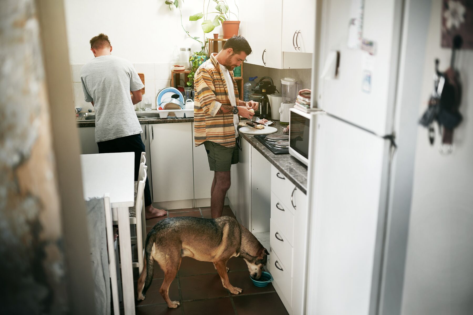 Two men cook in a kitchen.