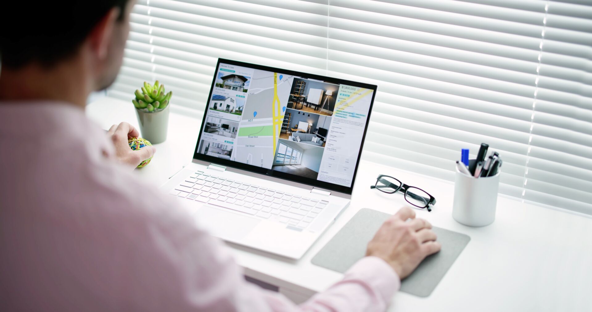 A man sits and uses a tablet with a keyboard while looking at a real estate listing.