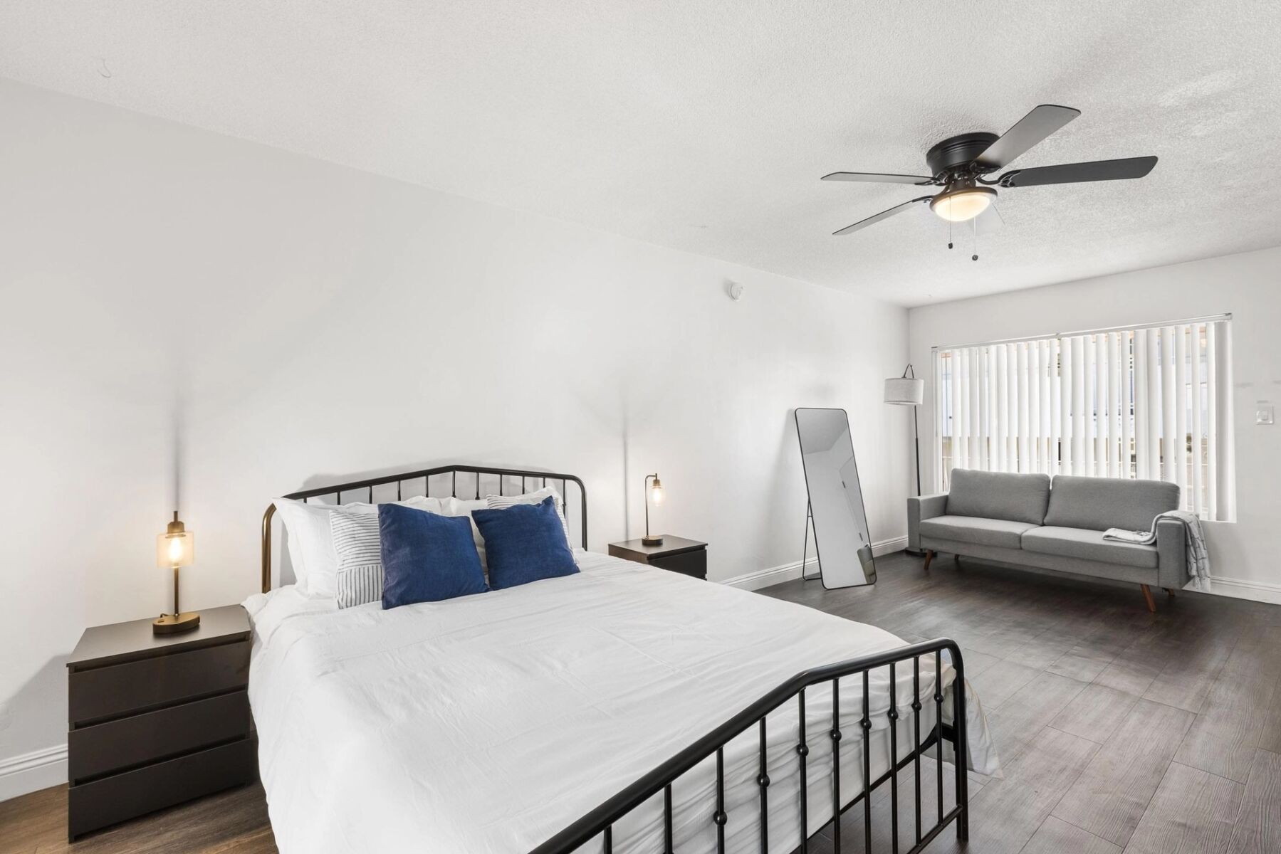 An image of a bedroom with a bed and couch.