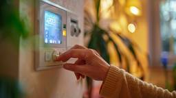 Energy-efficient properties for investment are often equipped with smart features. This image shows a hand adjusting a smart meter, managing energy consumption.
