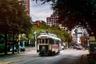 A trolley going down the road in downtown Dallas, Texas neighborhood.