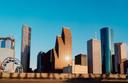 View of Houston, Texas downtown skyscrapers with blue skies in the background.