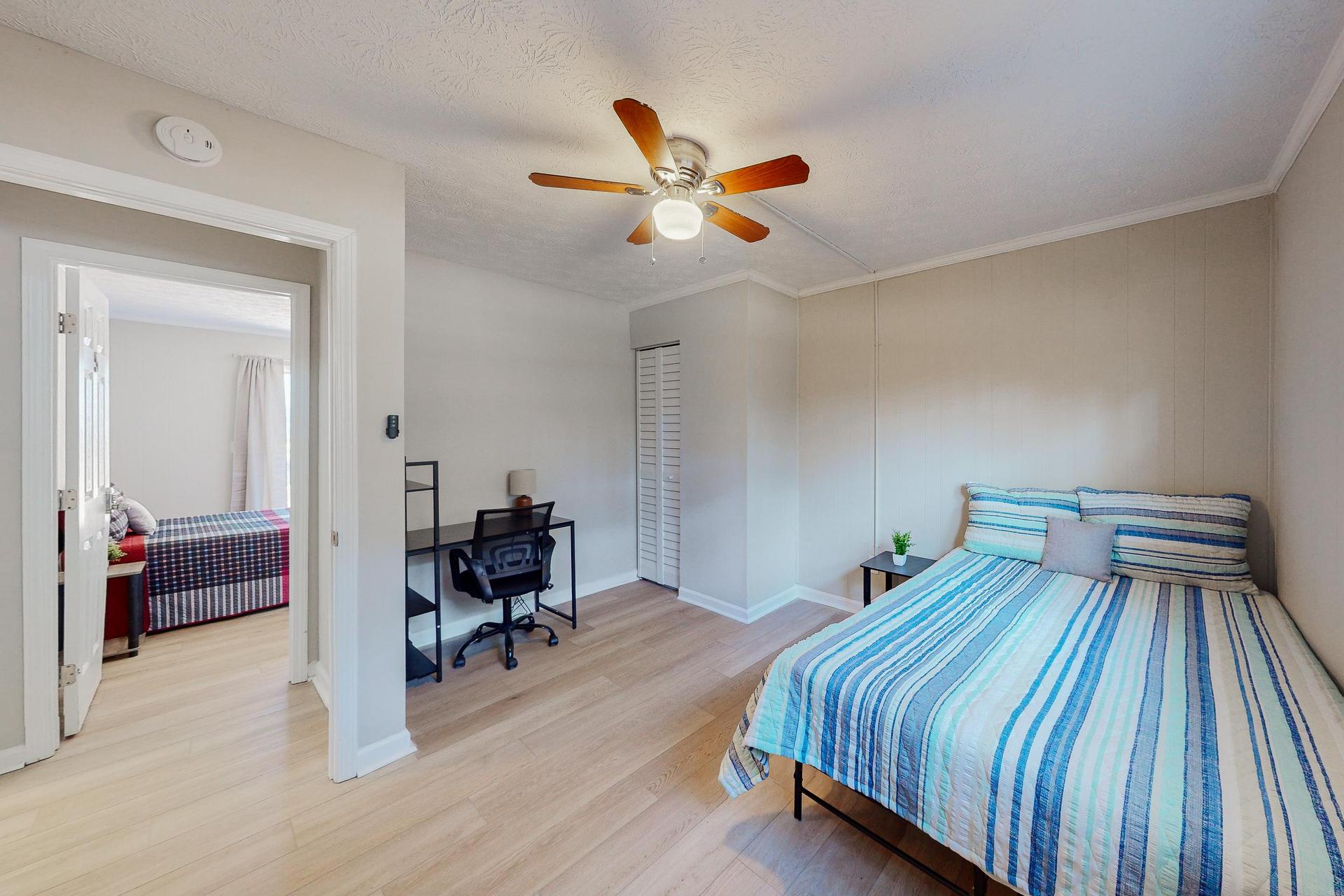Office desk & chair tucked away beside enclosed closet.