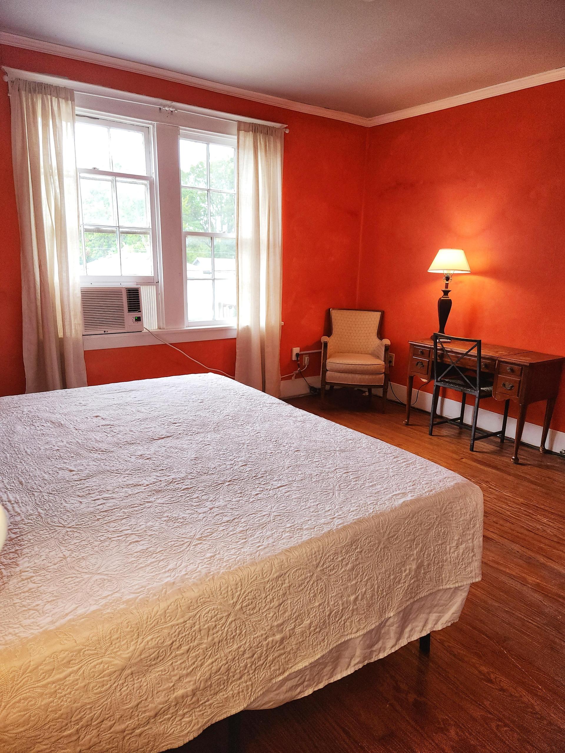 2nd Floor- Orange room. Side street view, 2 windows, King bed, wood floor, window AC/Heat unit, dedicated work station, no TV