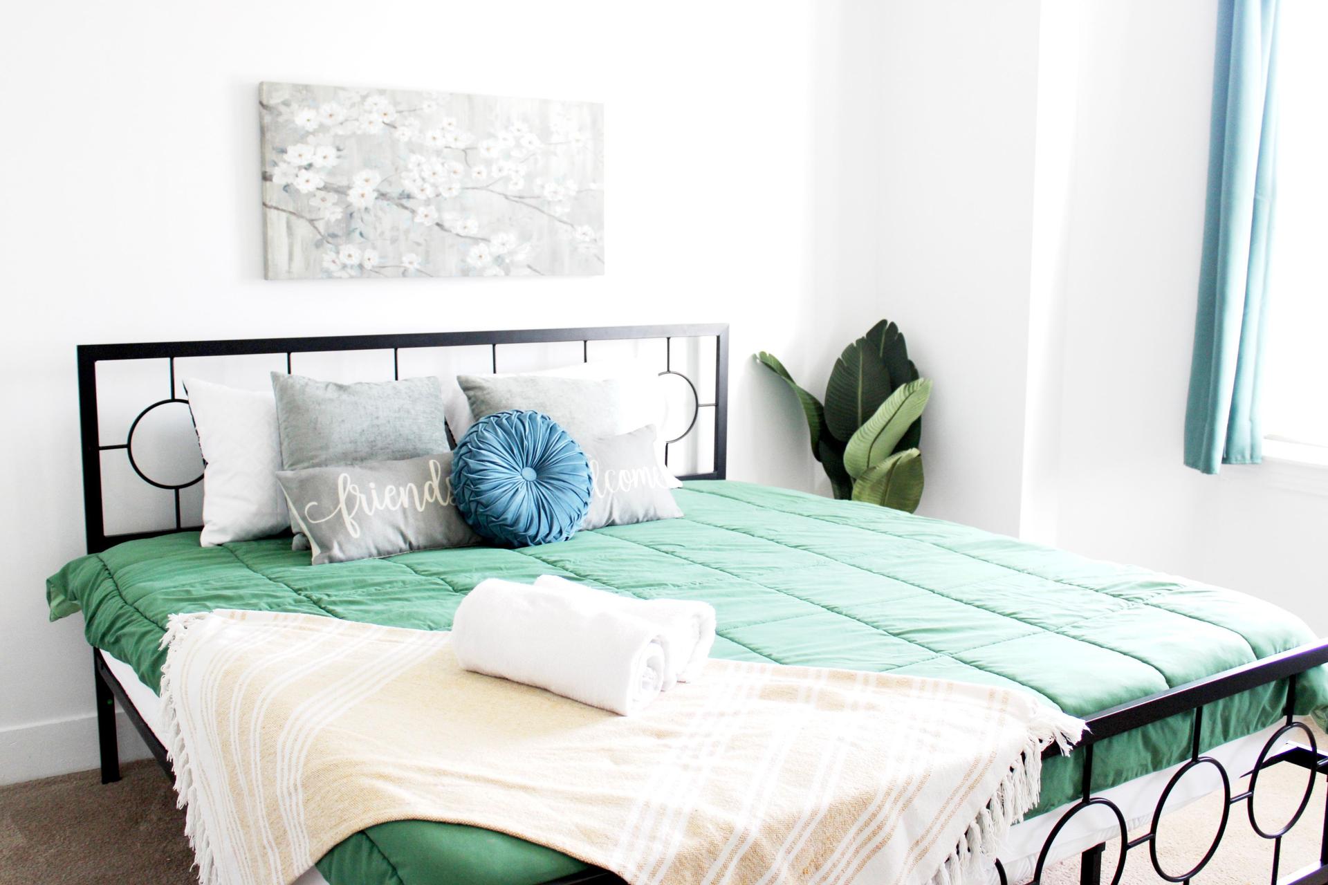 Spacious and comfortable room featuring a Queen bed, 55-inch Smart TV, Wi-Fi, and a dedicated workspace.