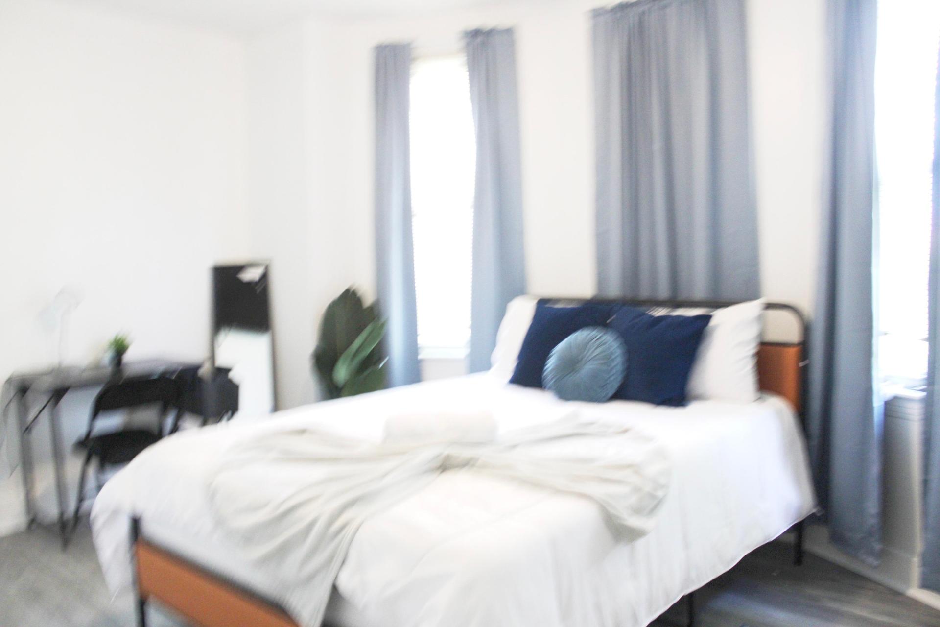Spacious and comfortable room featuring a Queen bed, 55-inch Smart TV, Wi-Fi, and a dedicated workspace.