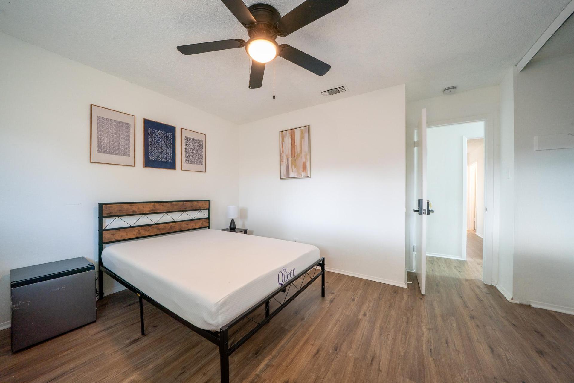 10ft x 12ft room with desk, chair, mini fridge, ceiling fan, closet and dresser.