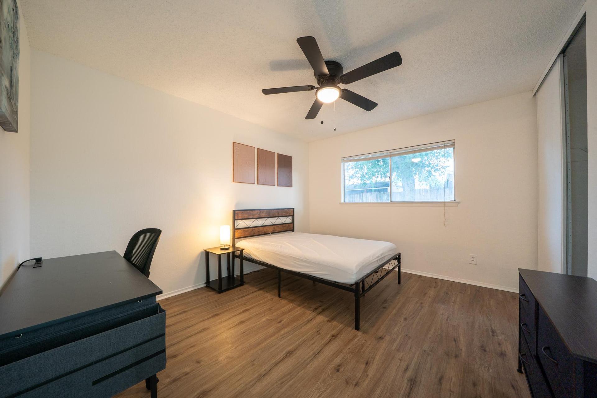 11ft x 12.5ft room with desk, chair, mini fridge, ceiling fan. closet and dresser.