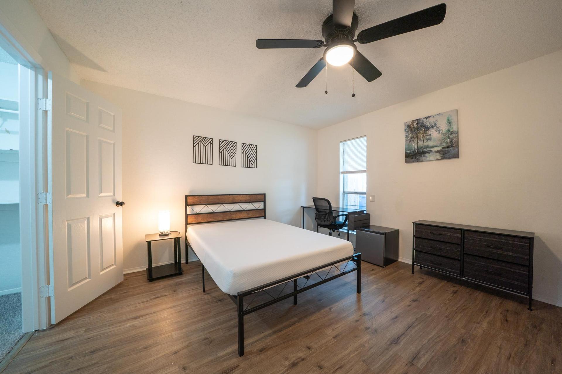 10ft x 13ft room with desk, chair, mini fridge, ceiling fan, walk in closet and dresser.
