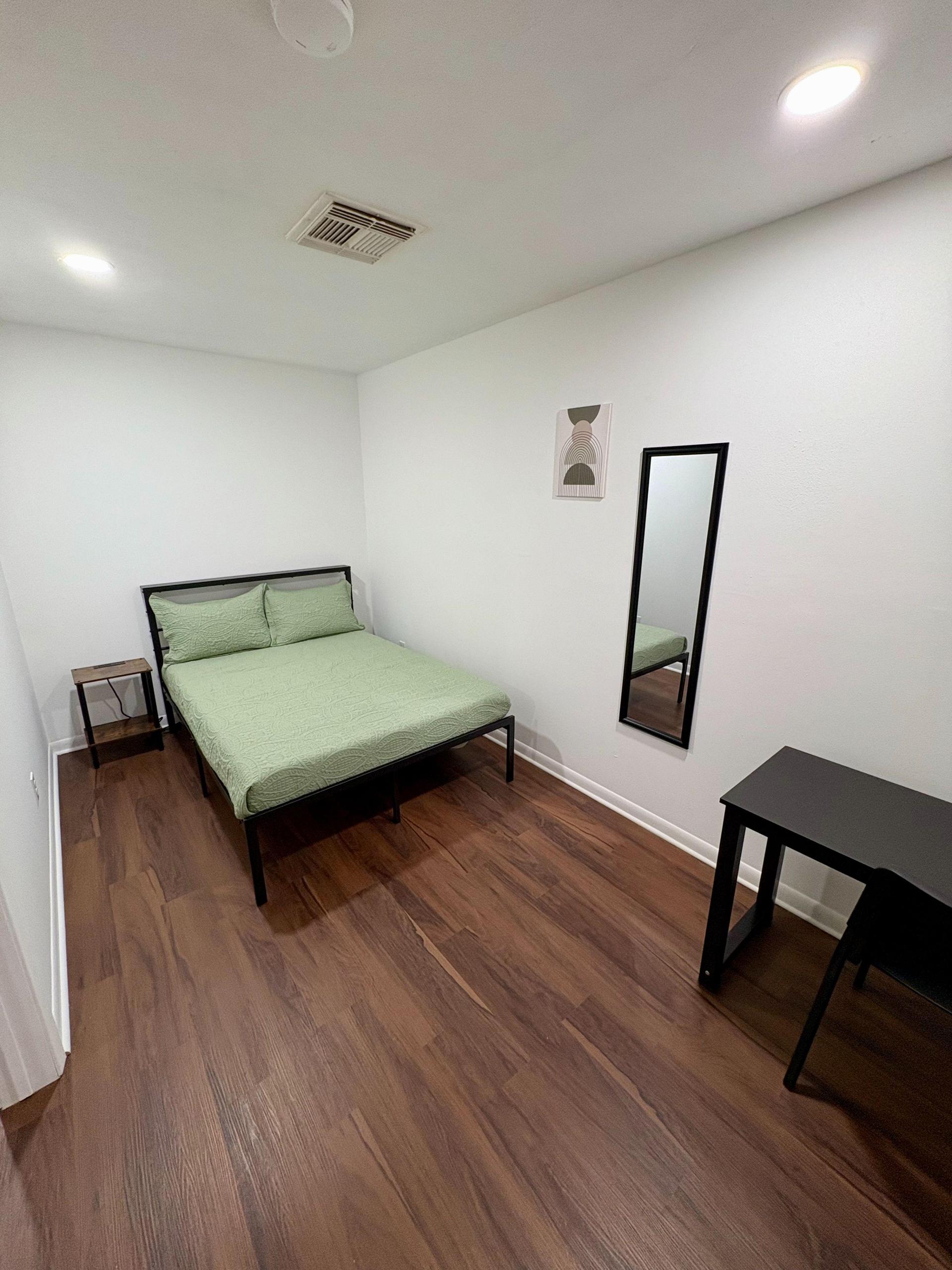 Room 4 features a full size bed, reach in closet, bedside table with a charging station, a work station, and private entry.