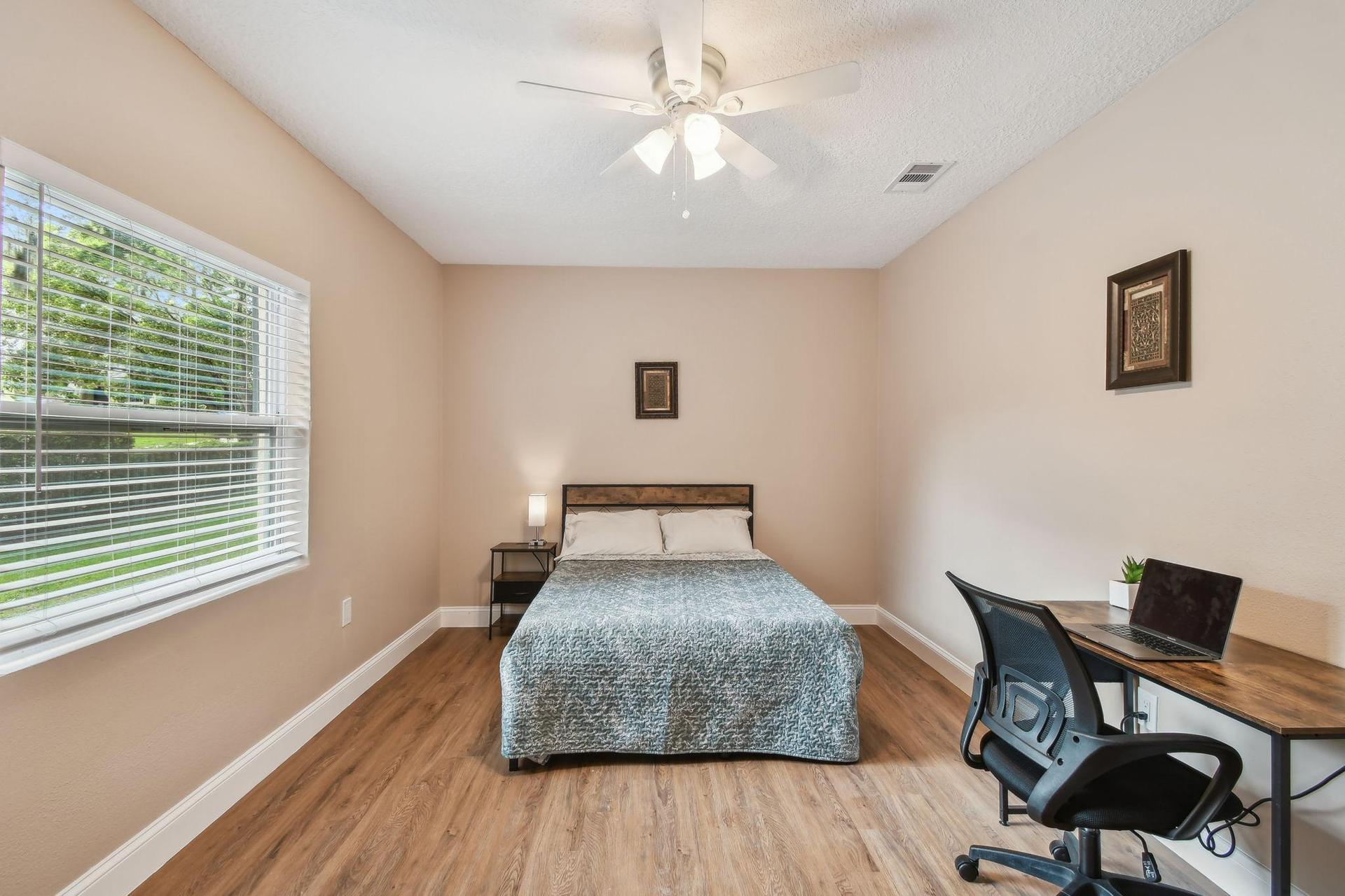 Full size cozy bed, with end table, light, desk, office chair, storage container under the bed and large Armoire.