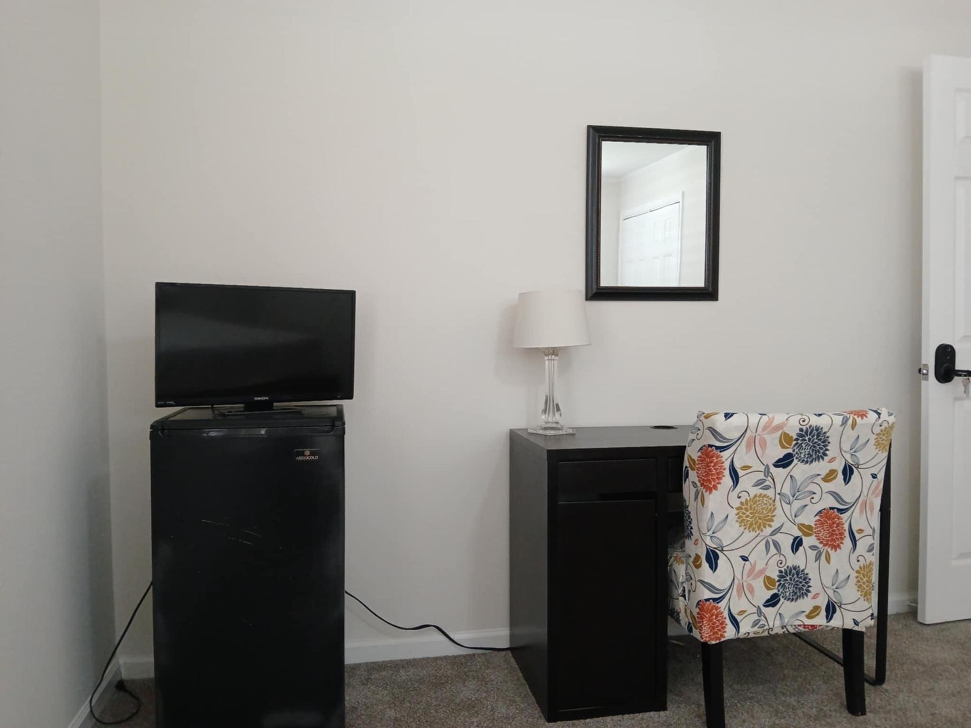 Mini Fridge, television and workstation with flexible seating area
