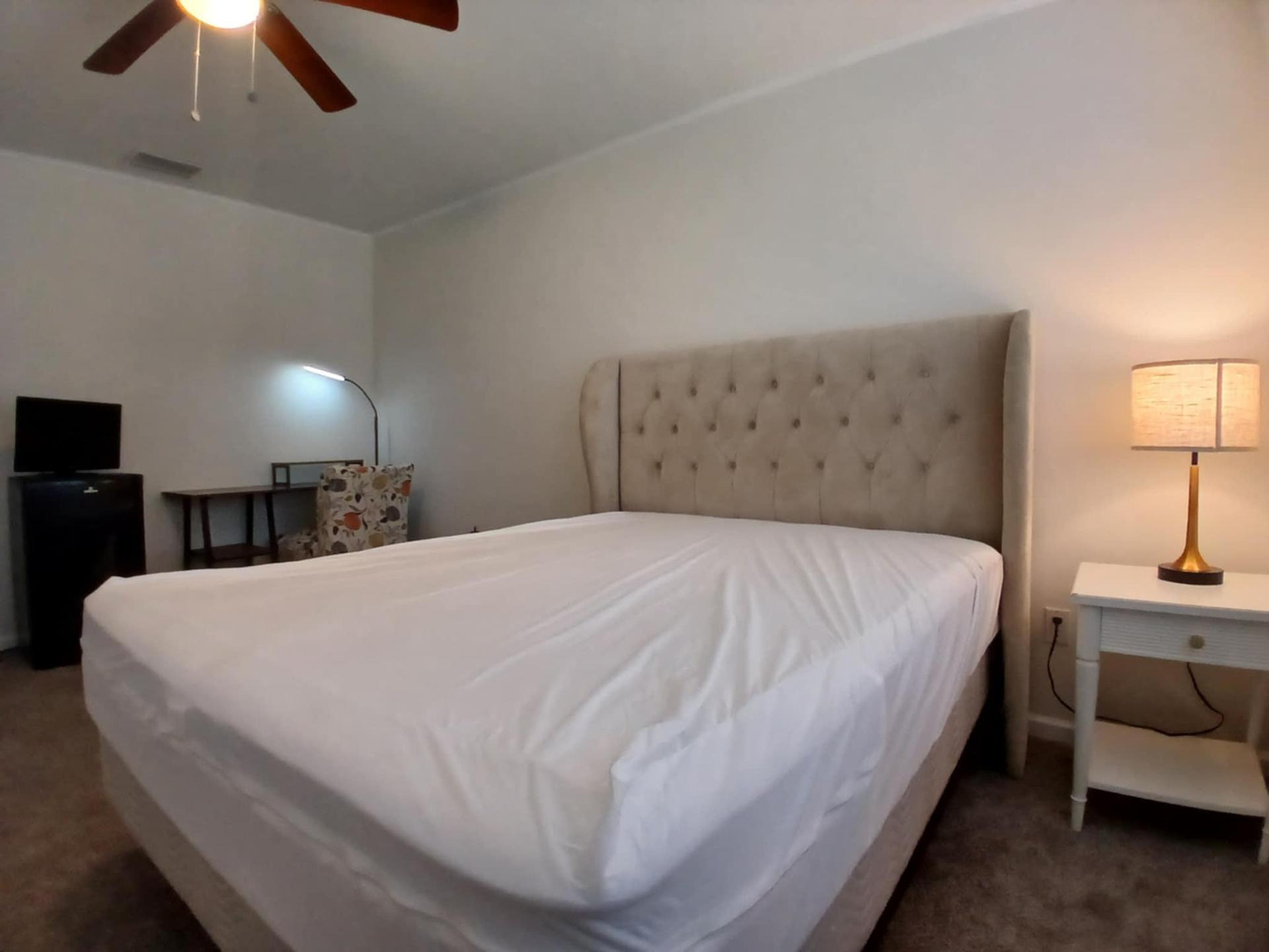 Queen-sized mattress with oversize upholstered headboard.