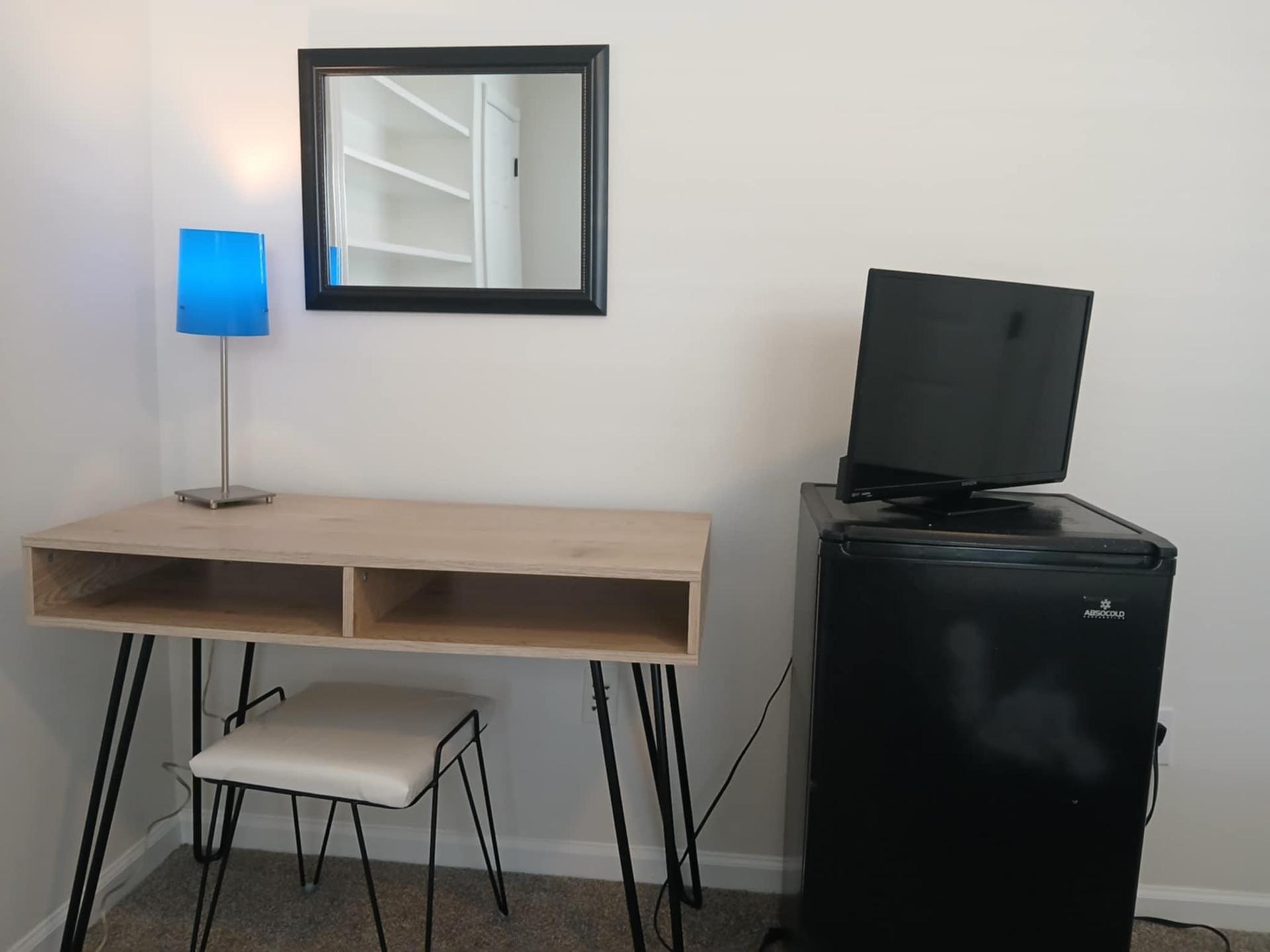 Workstation with mini-fridge and television.