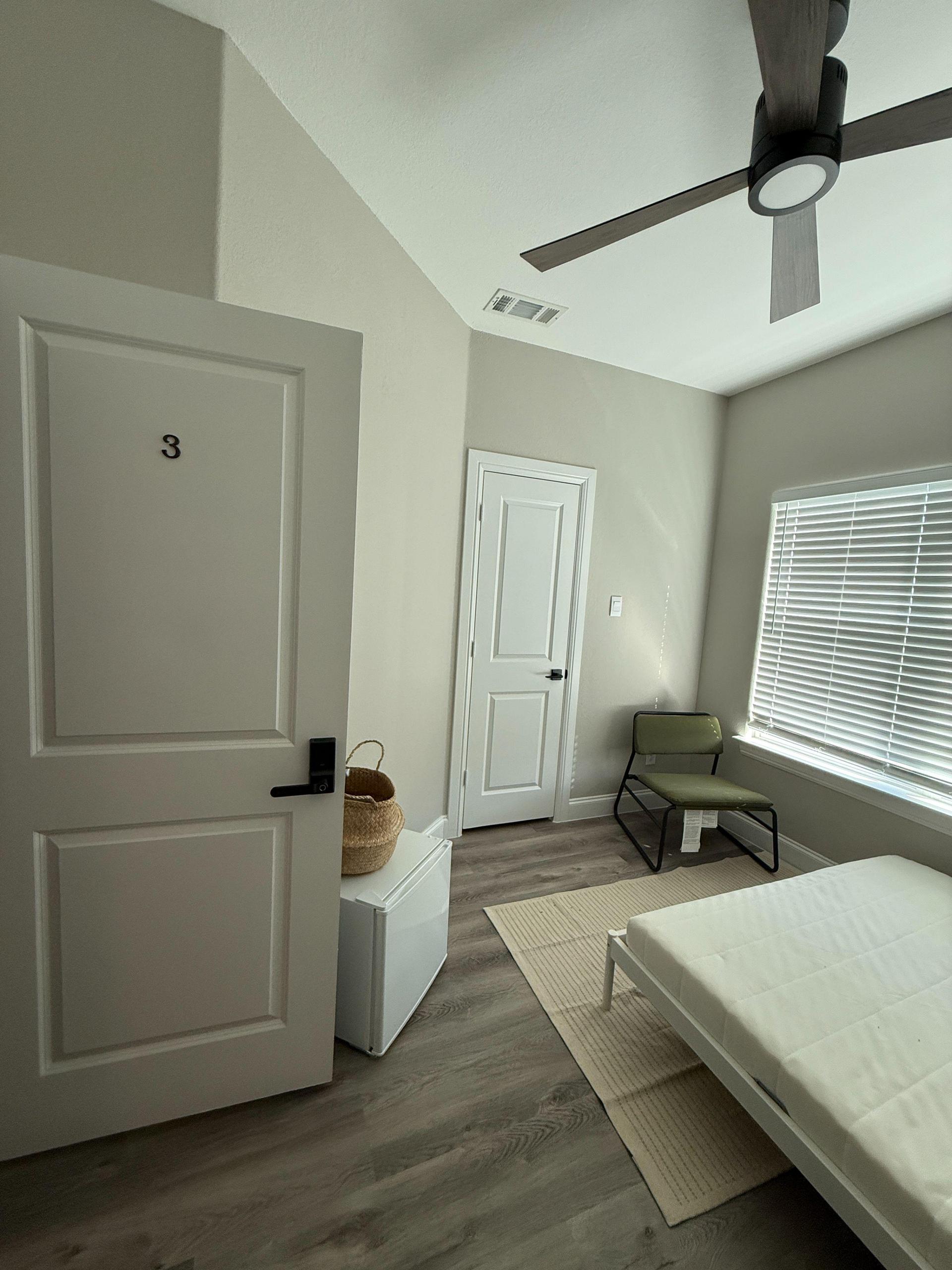 Mini fridge, white sound machine and full size bed