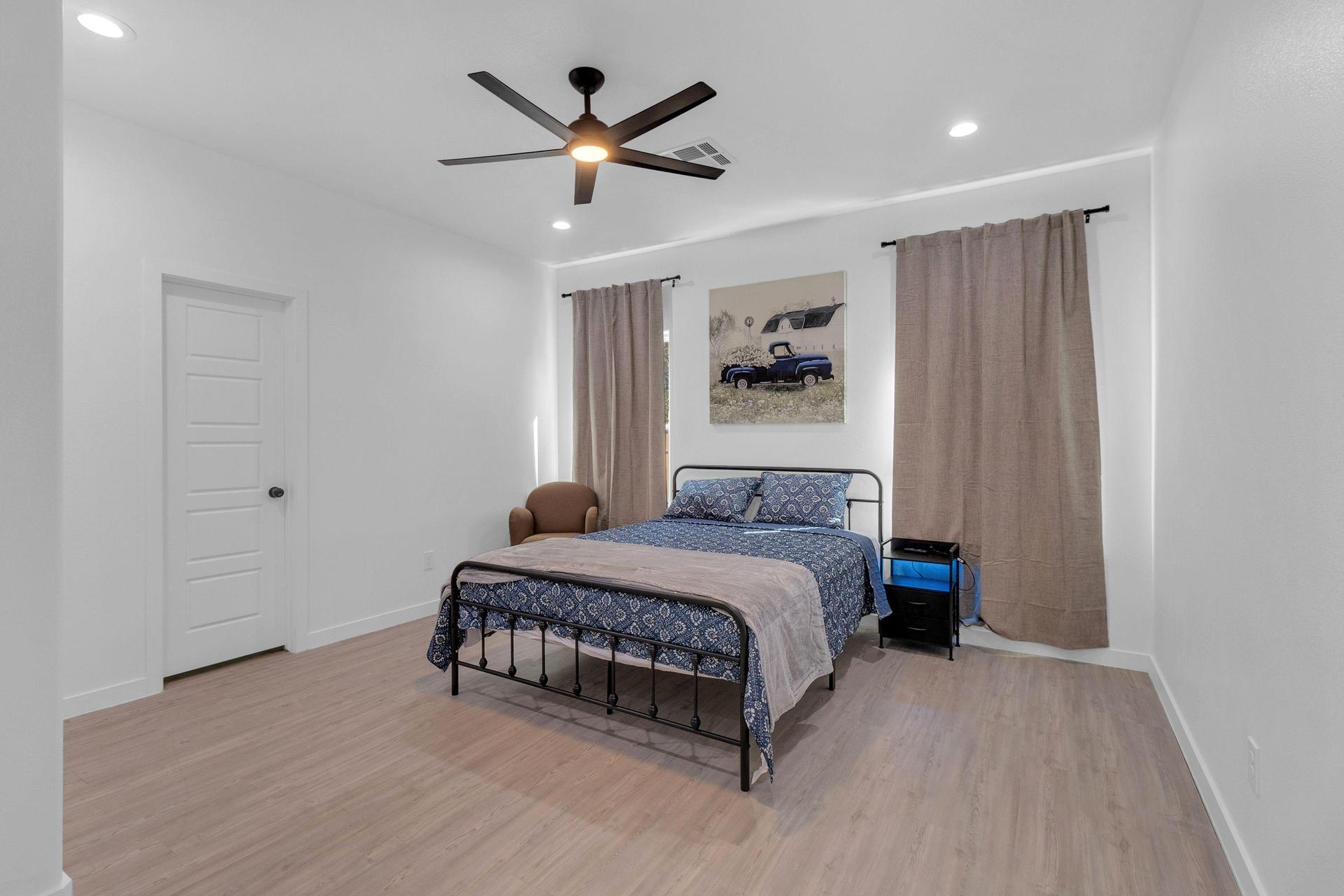 Comfy Queen Bed, nightstand and couch. Bathroom Door Closed