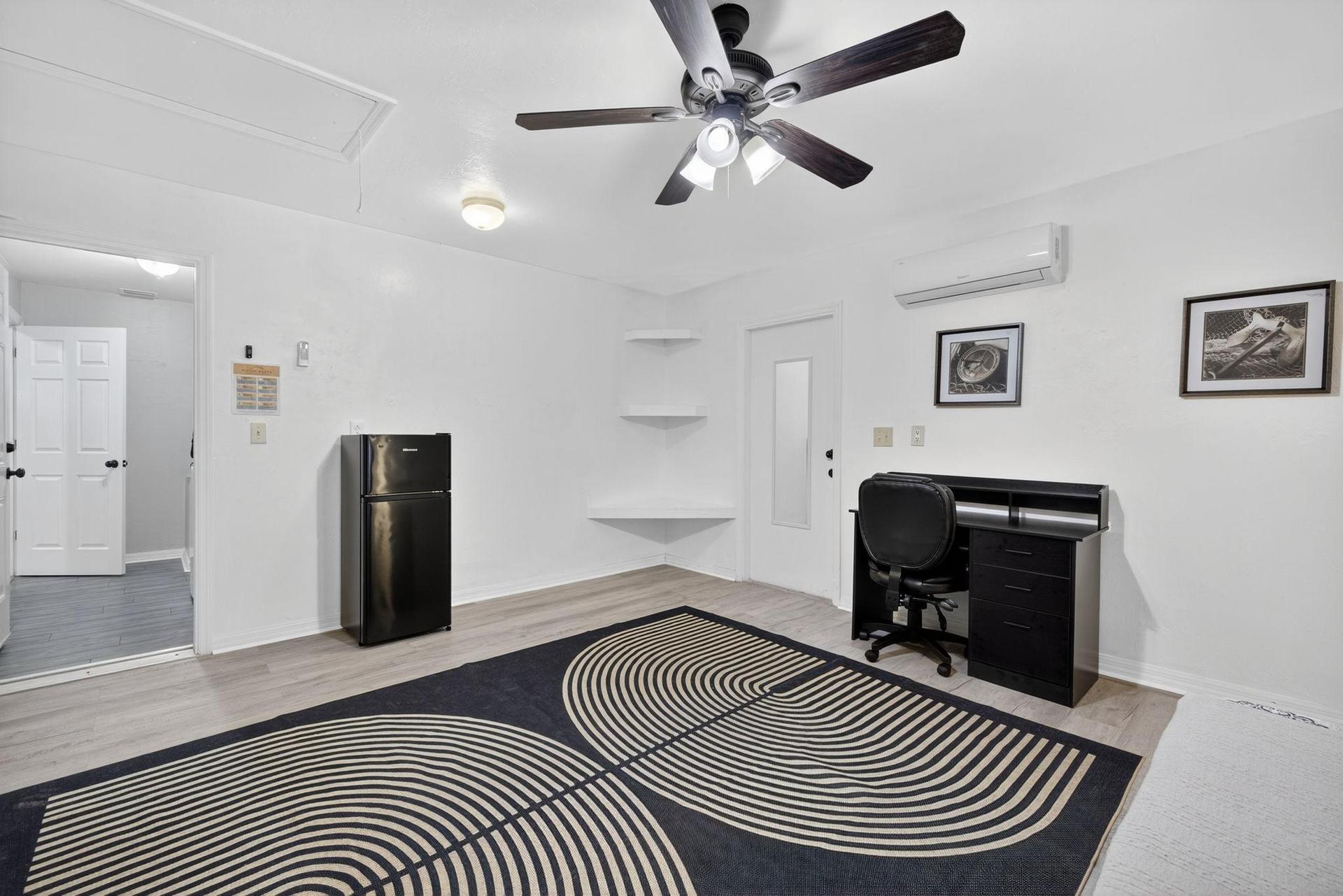 Bedroom 7 features a mini refrigerator, open shelving, a mini-split AC and a dedicated workspace