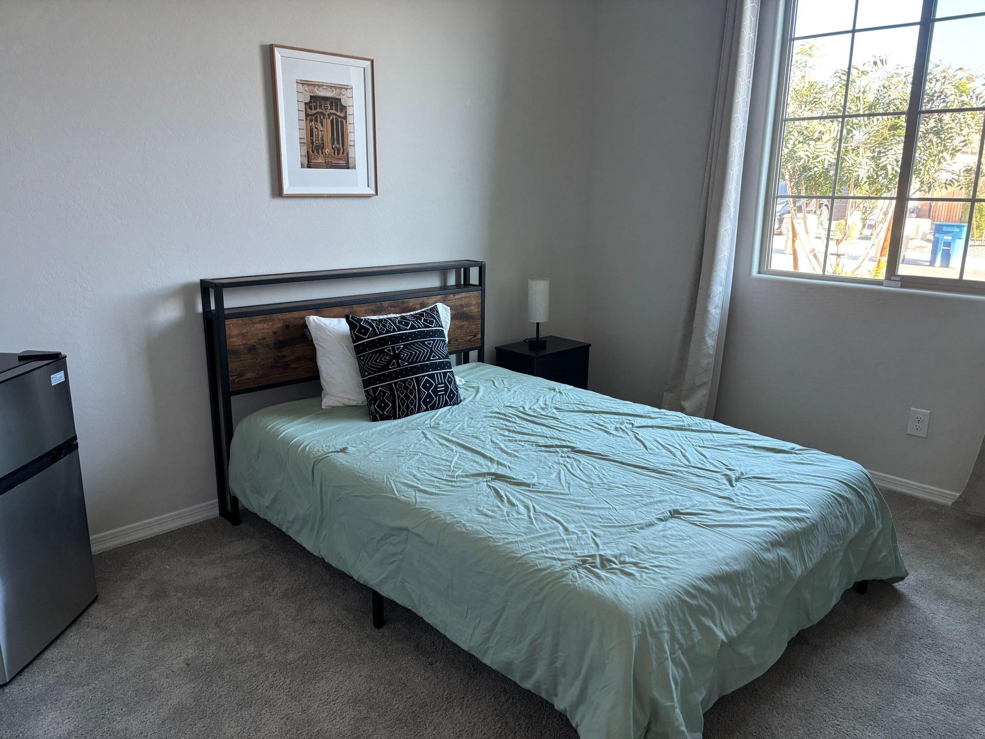 Full size bed, refrigerator and nightstand