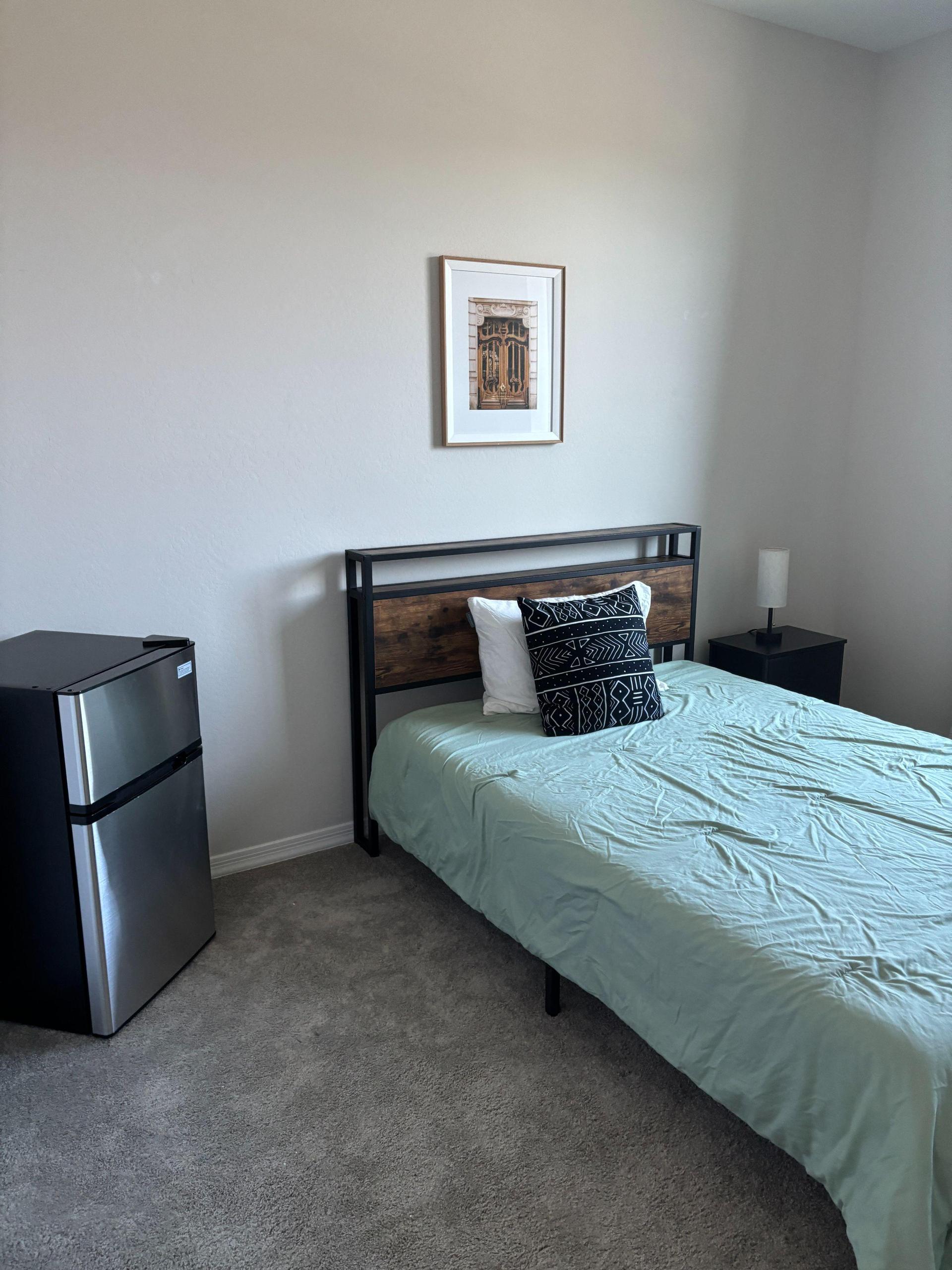 Full size bed, refrigerator and nightstand