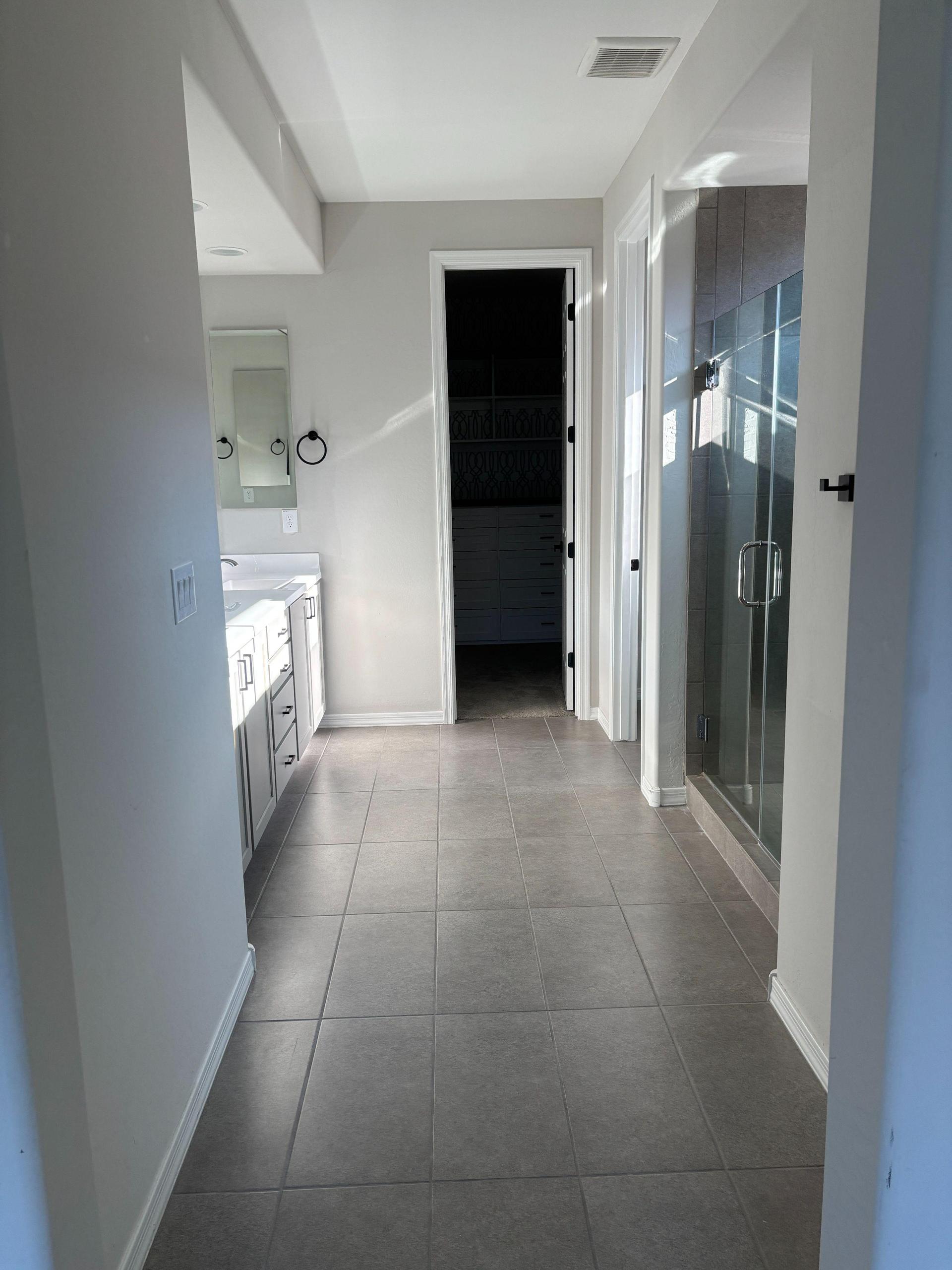 Full bathroom with walk-in shower, dual sinks and water closet.