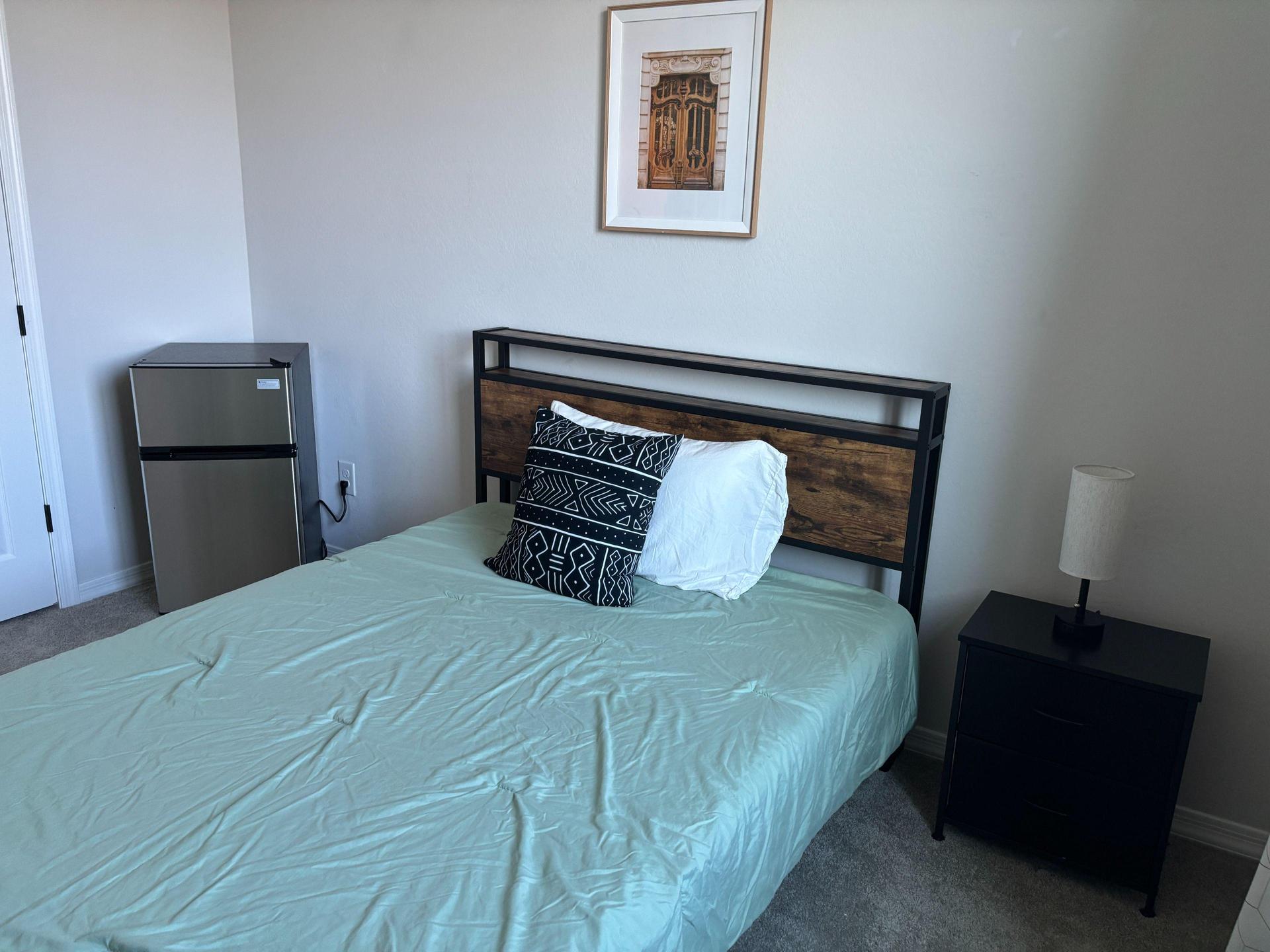 Full size bed, refrigerator and nightstand