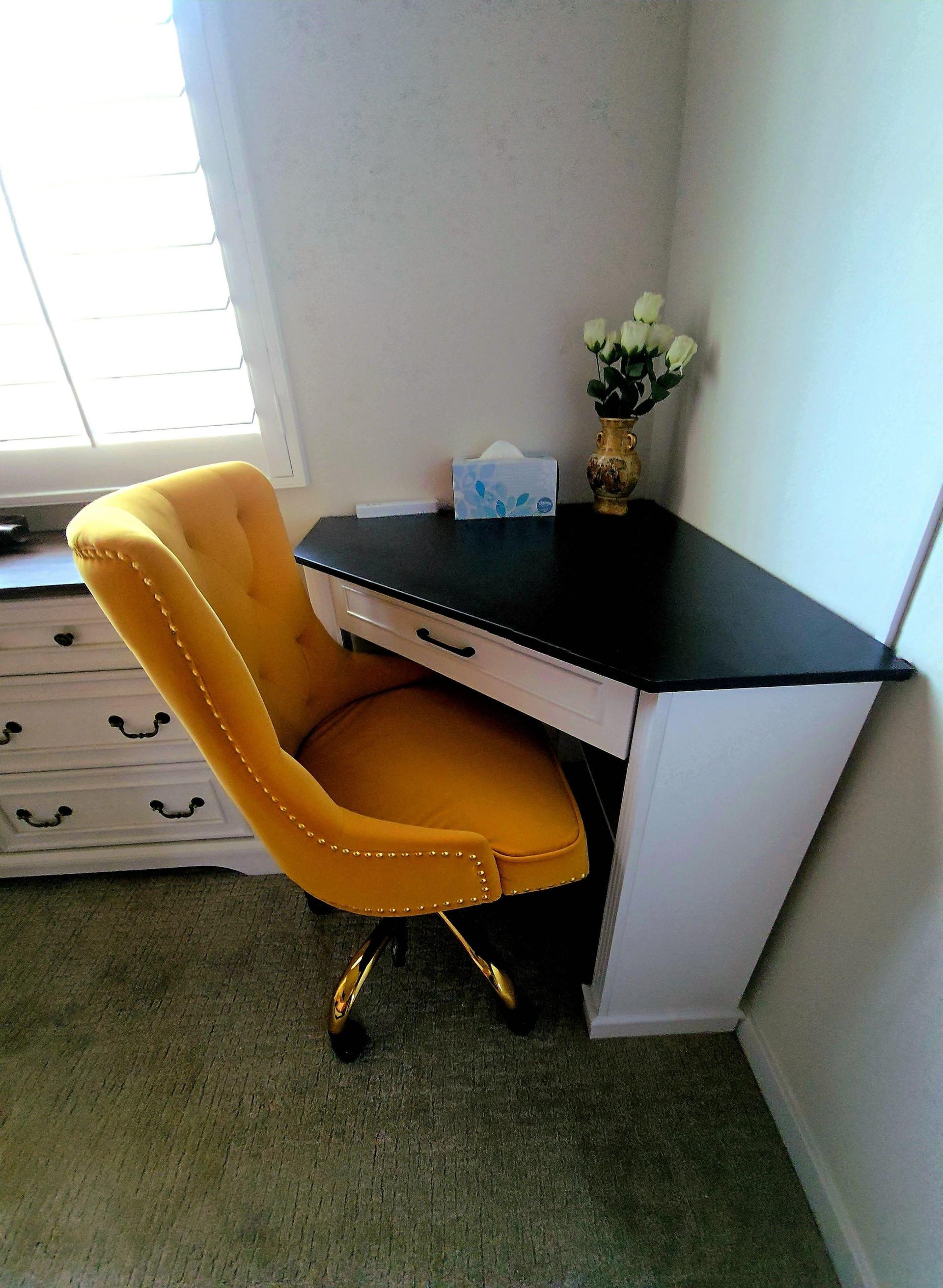 Workstation with sleek desk, sandstone-colored chair, white flowers, and soft natural light—ideal for focus or creative flow.