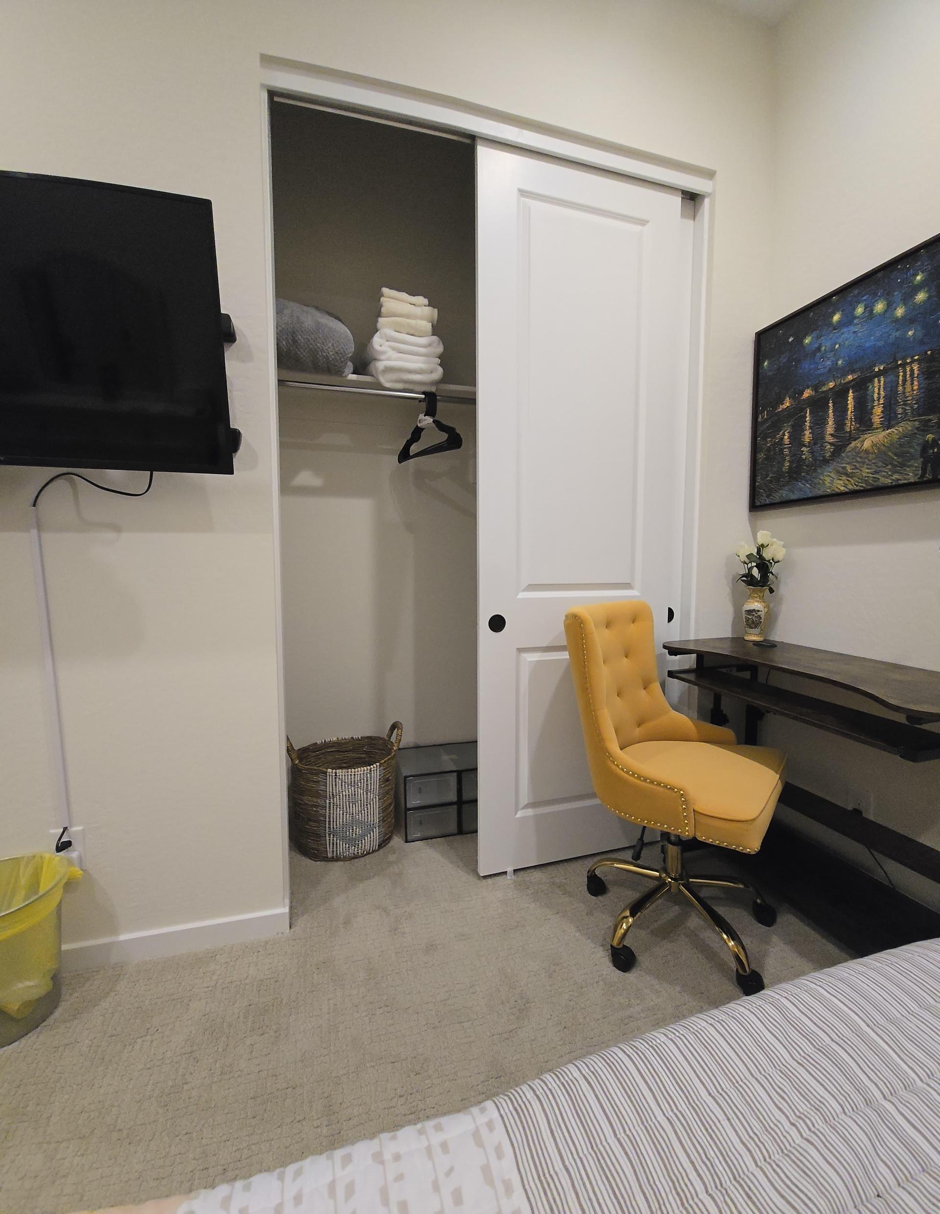 Closet with shelves, hangers, folded towels, laundry basket, and storage drawers. Sliding door keeps it clean and discreet.