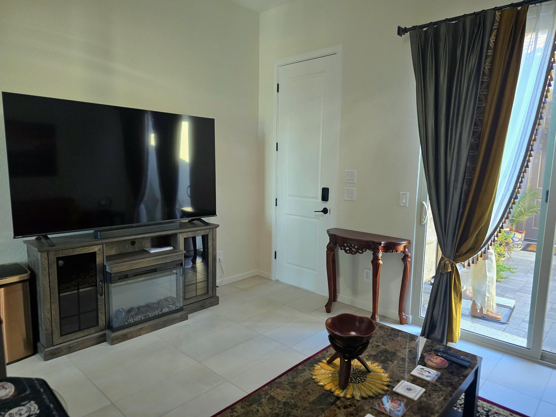 Lounge area with comfy seating, smart TV, elegant decor, and private entrance—perfect for relaxing in style and privacy.