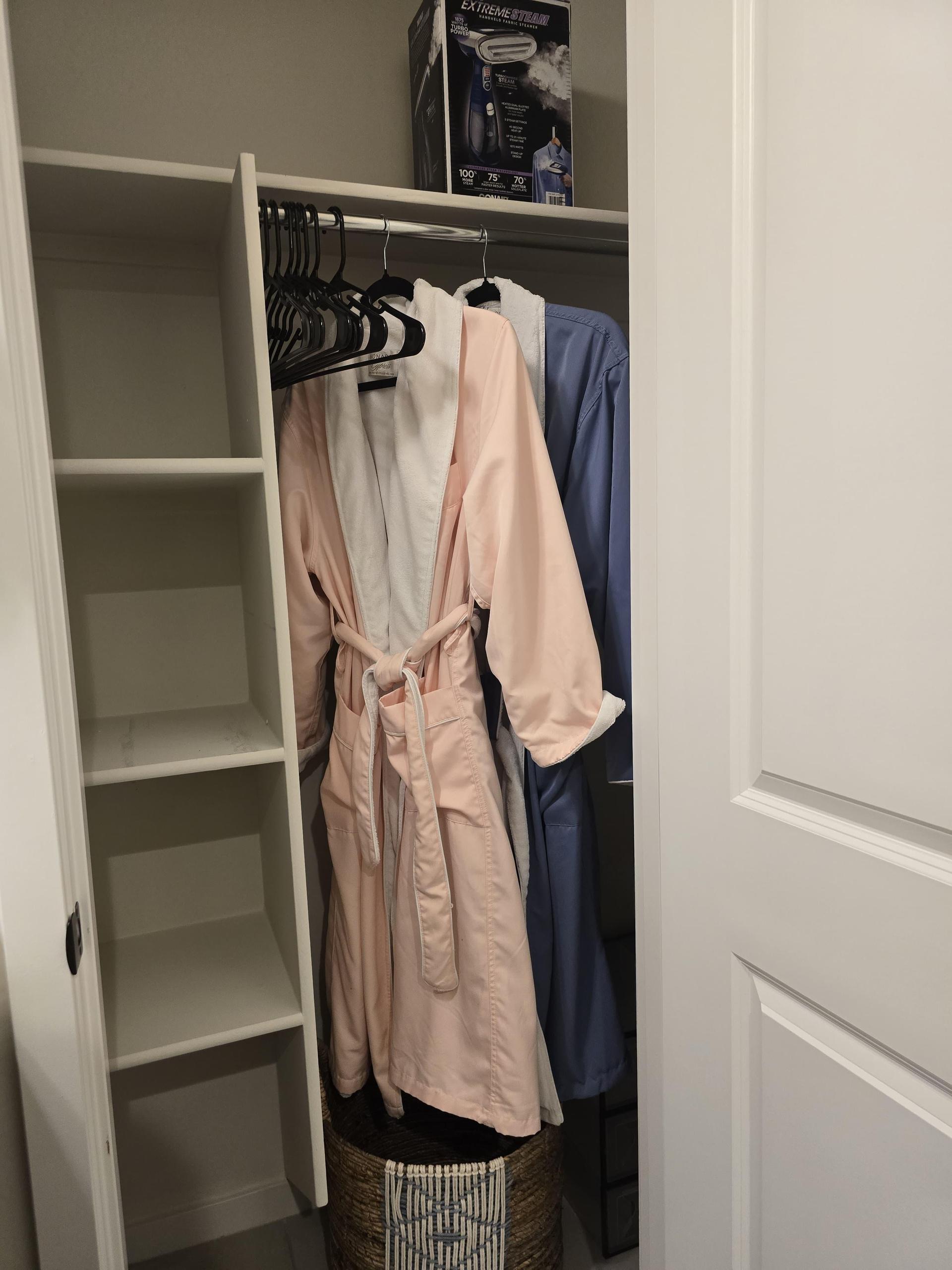 Closet includes robes, cubbies, a woven basket, and a steamer—organized, guest-ready, and perfect for a polished stay.
