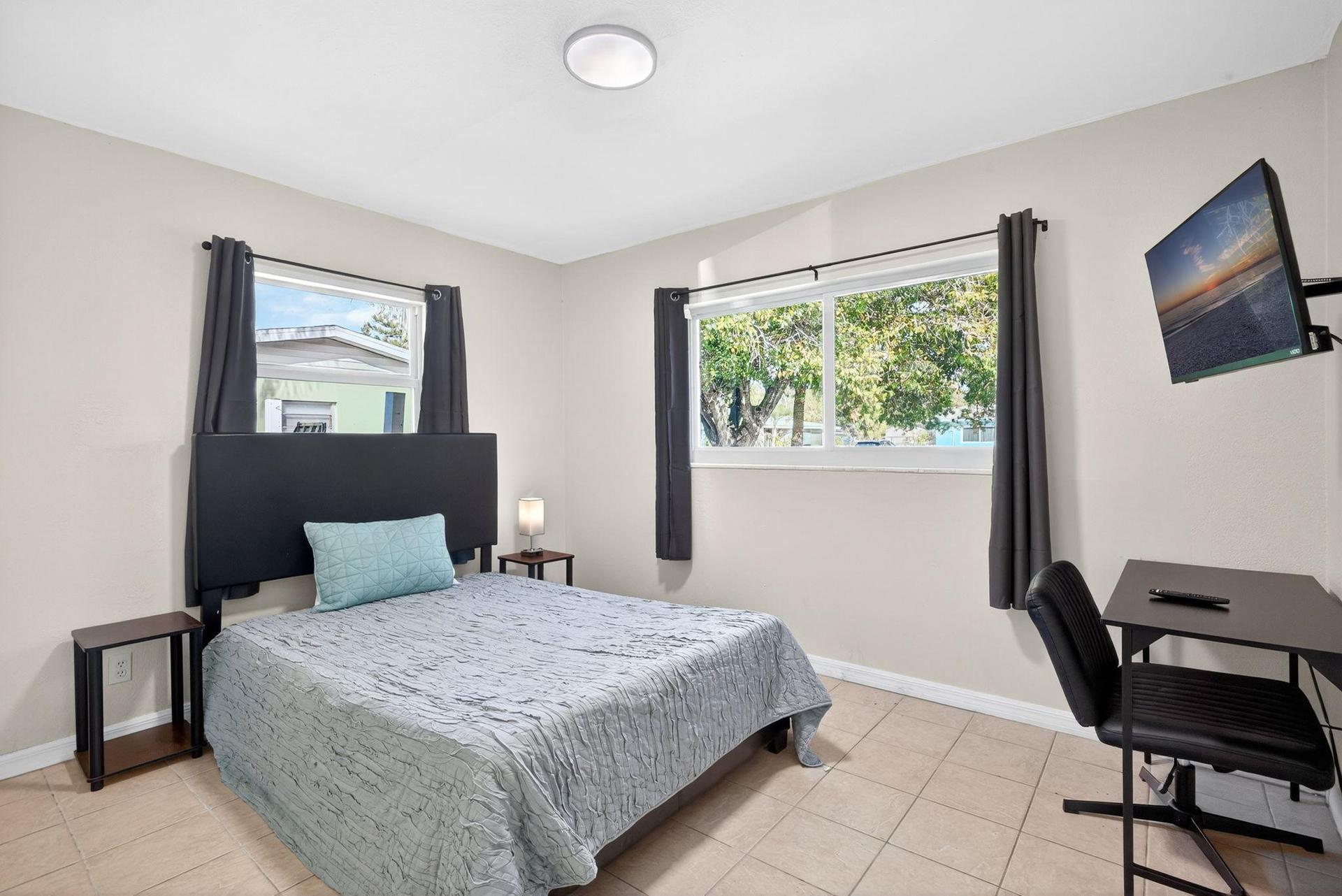 Large in-Suite bedroom with wall mounted Smart TV, Desk & chair, impact rated window