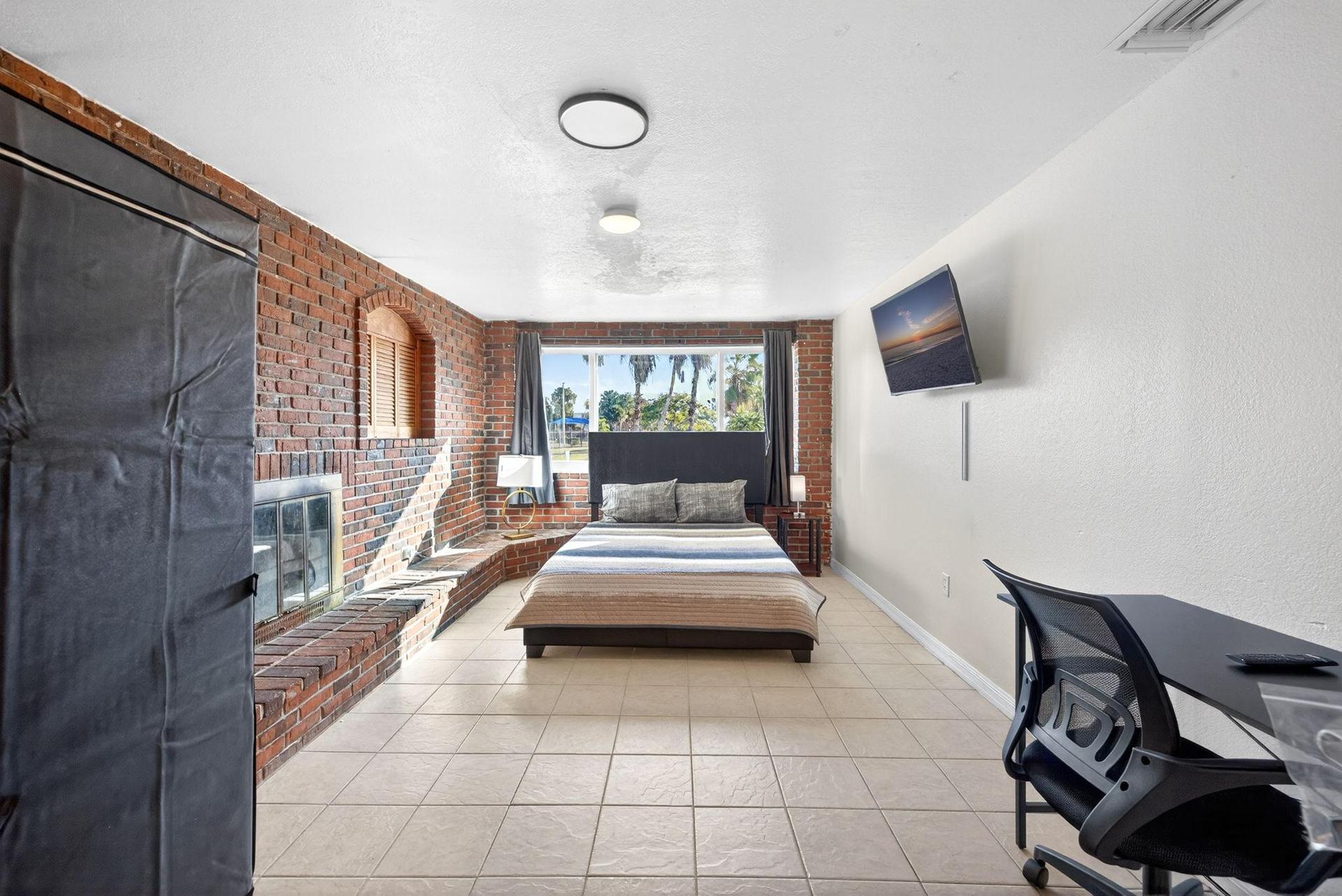 Large in-Suite bedroom with Queen Bed, Wall Mounted TV, Desk & chair