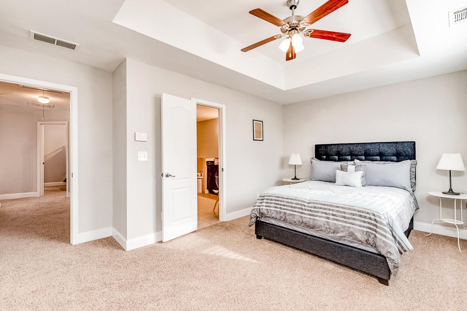 Queen bed with vaulted ceiling and ceiling fan. **Bedding not included.**