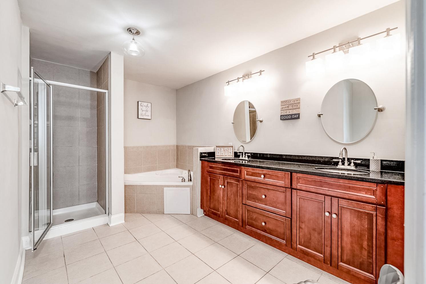Bathroom features private bath with jetted bathtub, stand-alone shower, and double vanity.