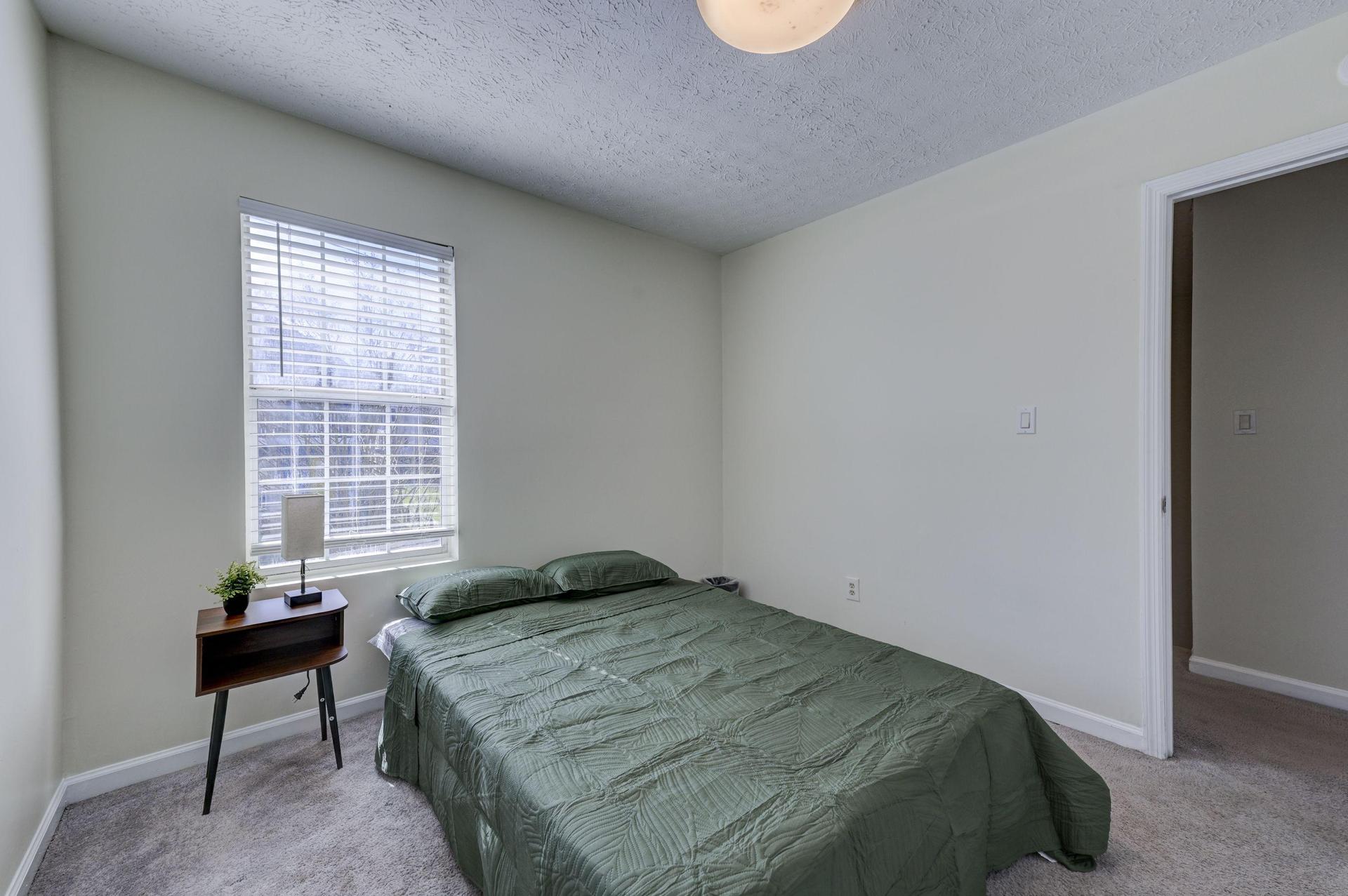 nightstand 🌙, lamp 💡, and trashcan 🗑️. For your convenience, a clean bathroom is located directly across the hall 🚿