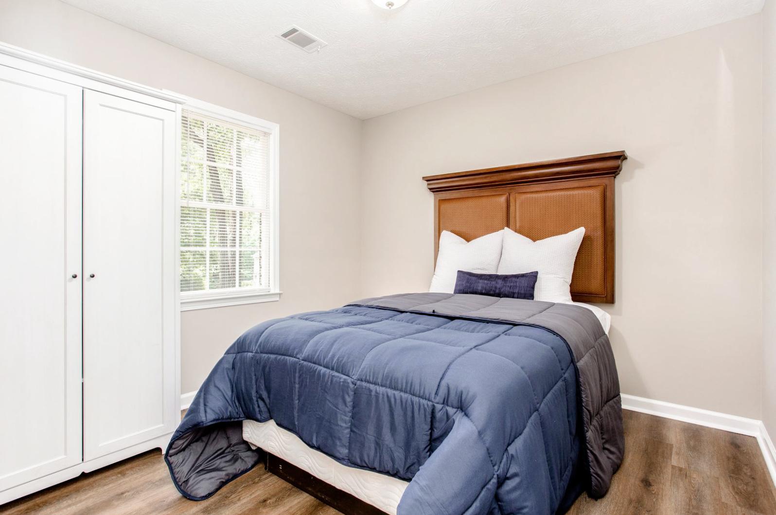Bedroom on main floor with nightstand and armoir.
