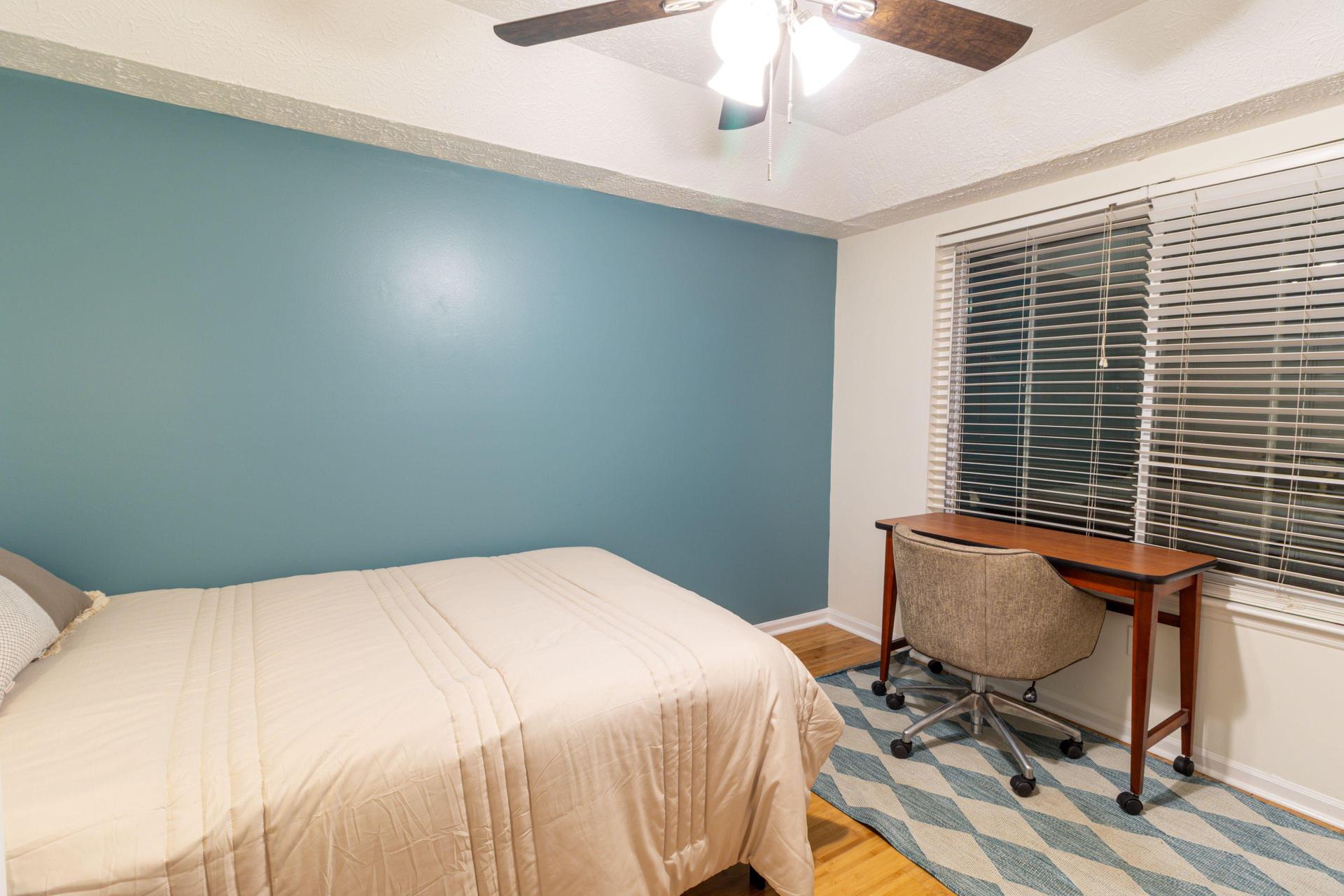 Desk with blinds open with view of backyard
