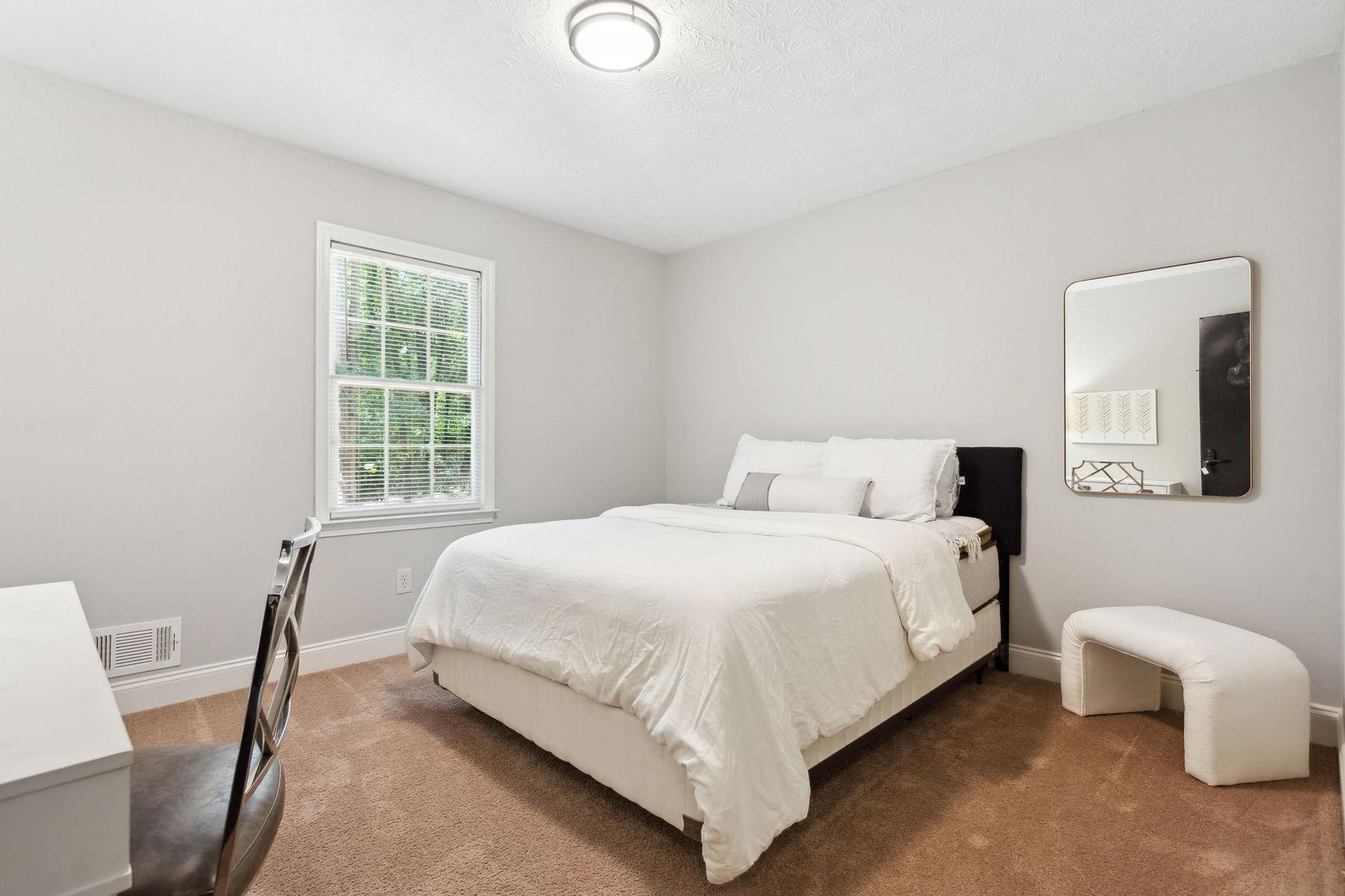 Room #2 with a desk a queen bed, art and a dresser.