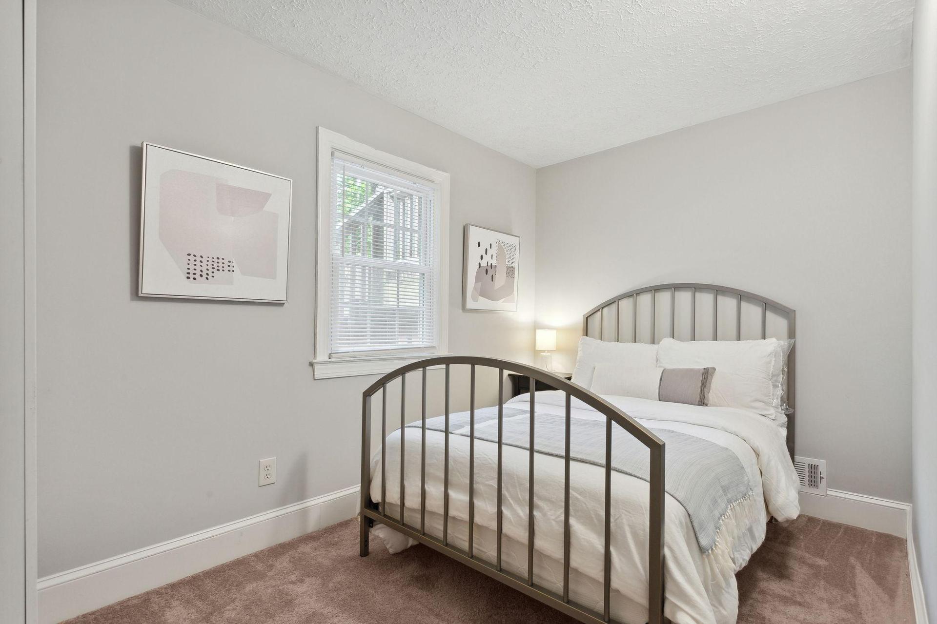 Room #5 with a  full bed, art and a wardrobe.