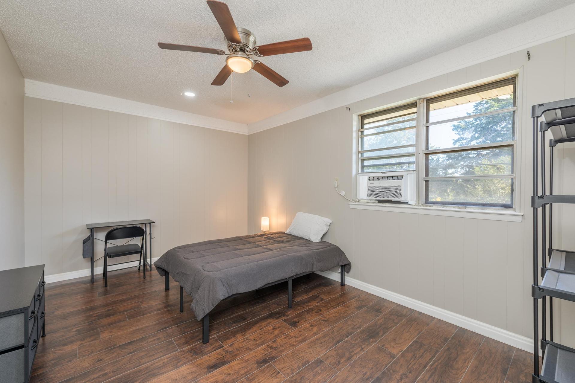 Room equipped with a full sized bed, dresser, wardrobe, trashcan, desk/chair, night stand and night light.