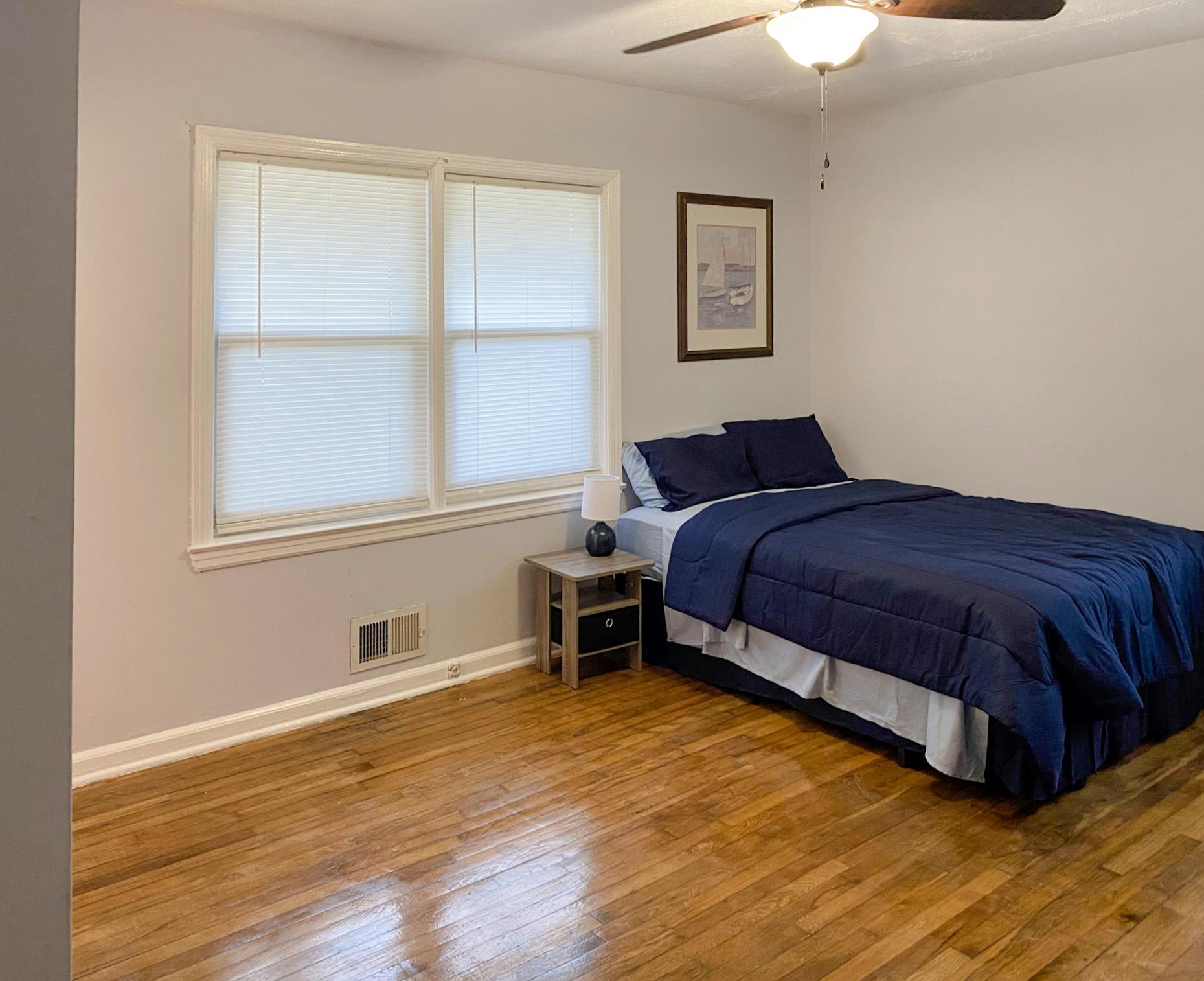 This spacious master bedroom has a private half bath, 8 drawer dresser, and new ceiling fan.