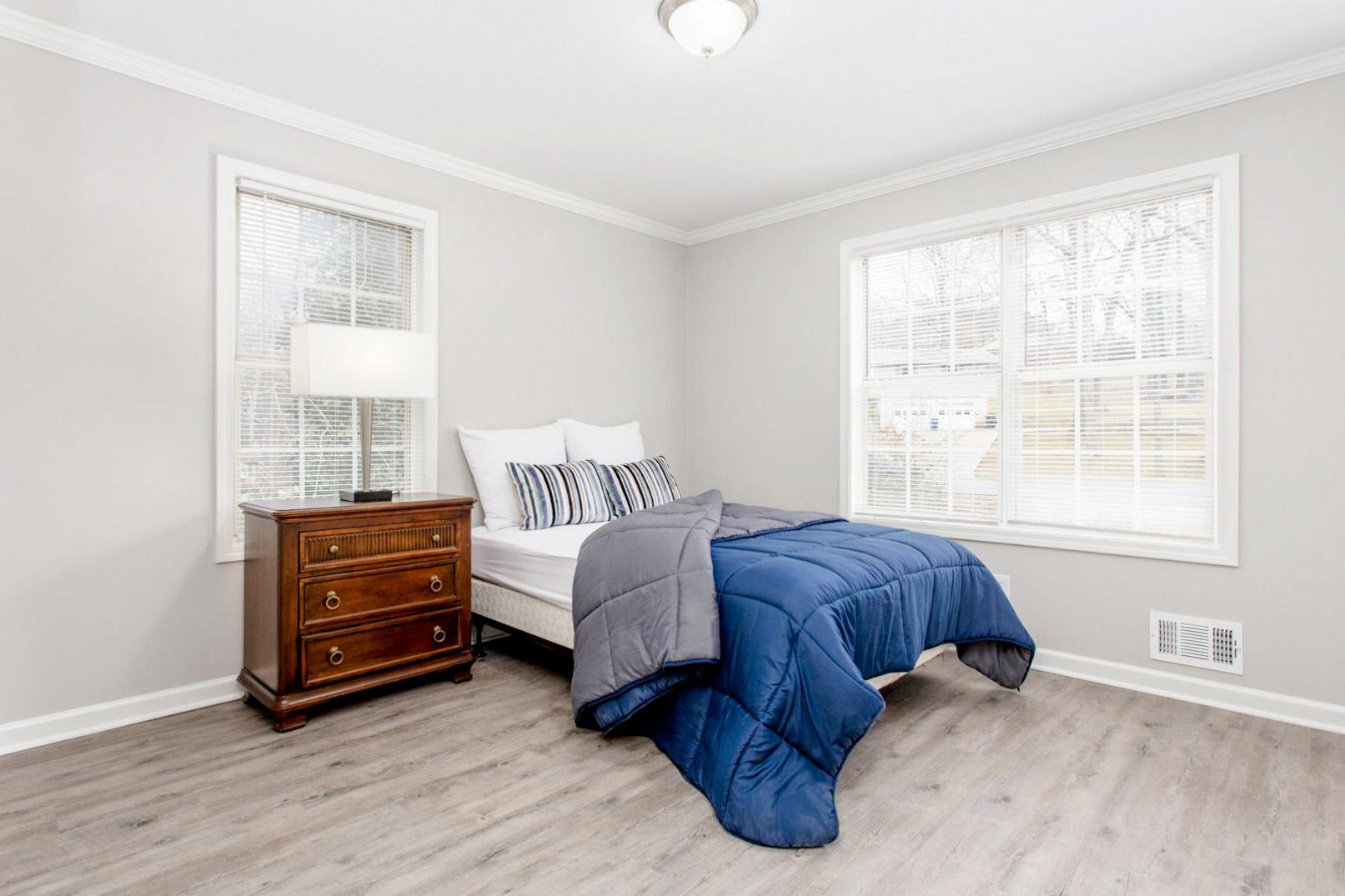 Large bedroom with closet, nightstand and lamp.