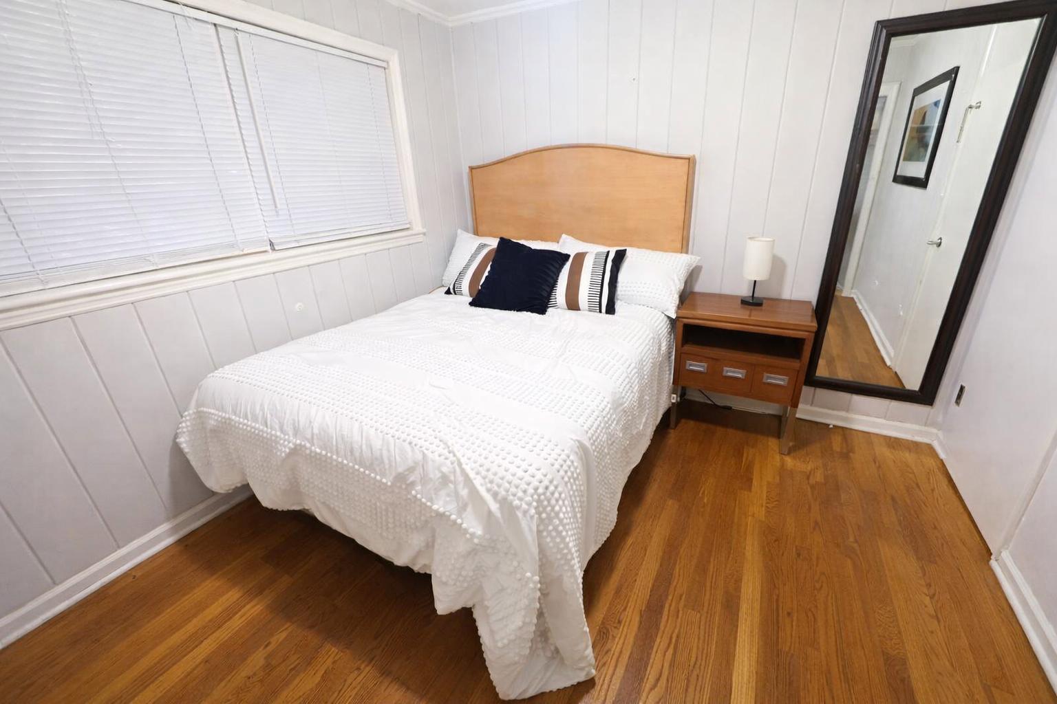 Queen bed, 2 windows, and a wall mirror