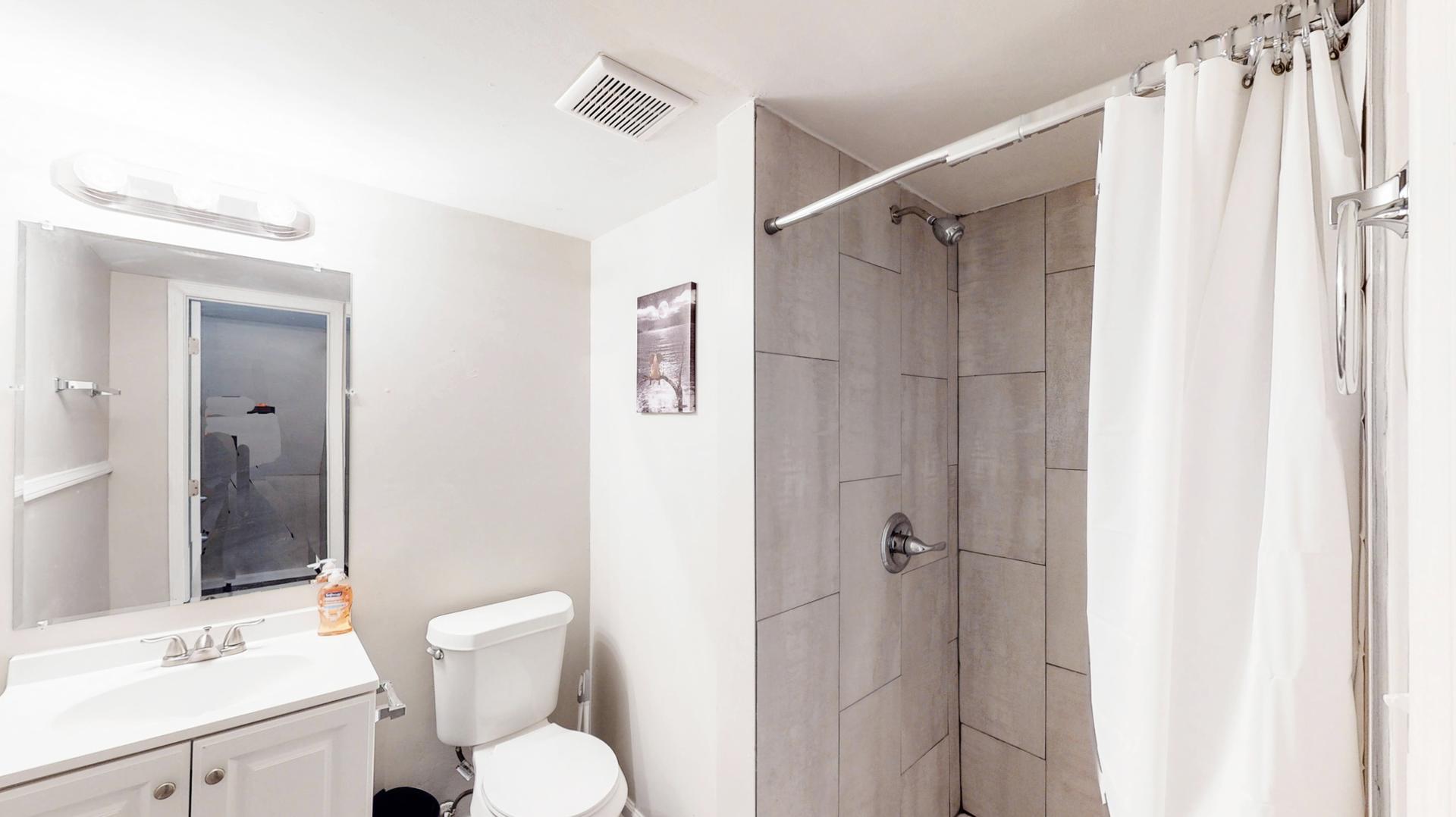 Shared lower level full bathroom with standing shower.