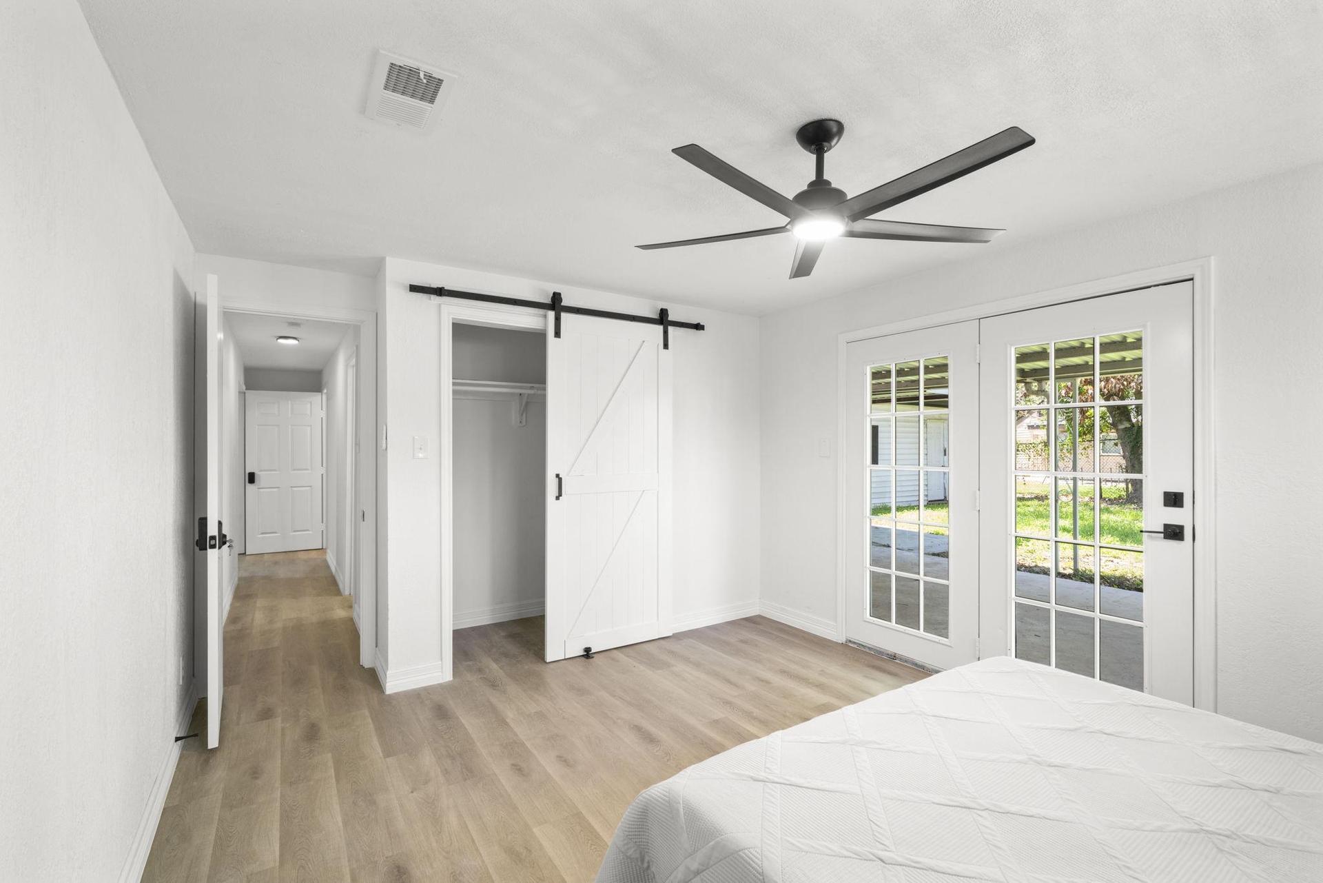 Standard room w/ queen bed, writing table, ceiling fan.