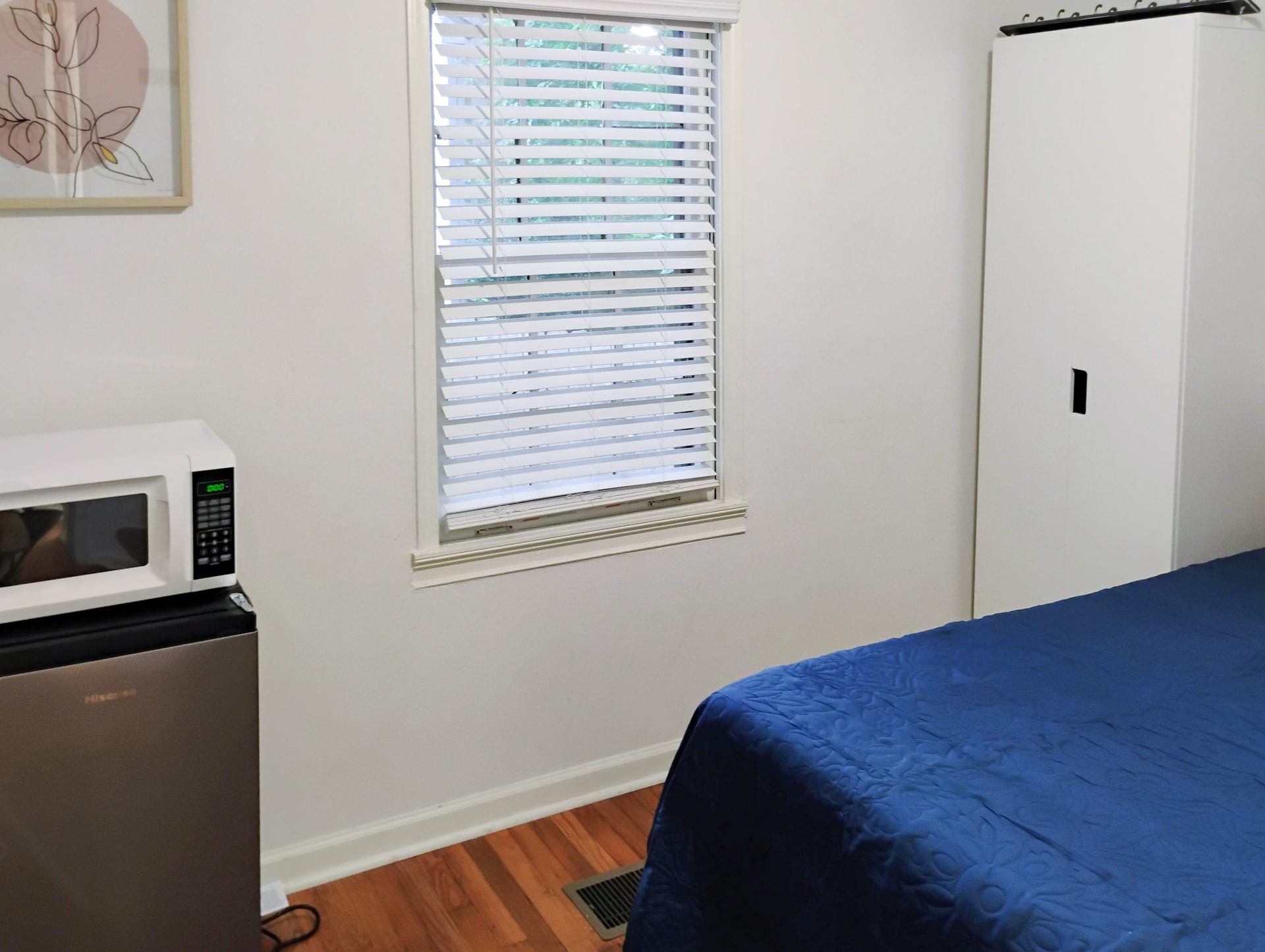 bedroom, detected:window blind, bed, microwave oven, stove