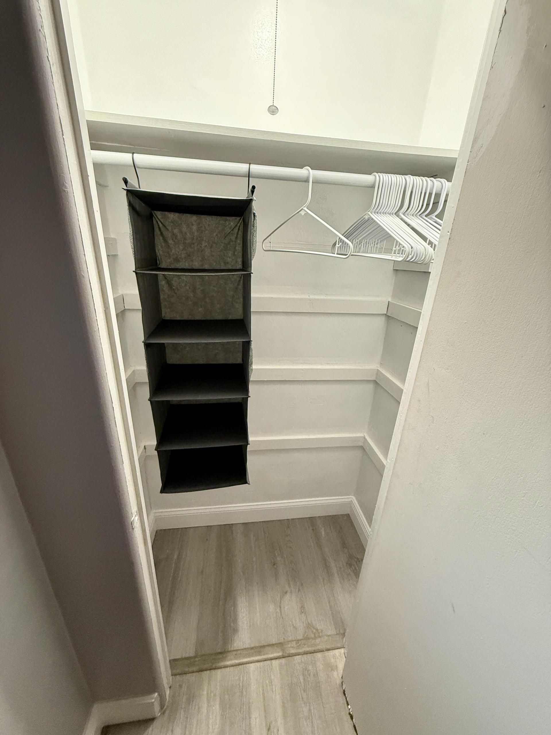 Full closet with plenty of story across hall from door to room
